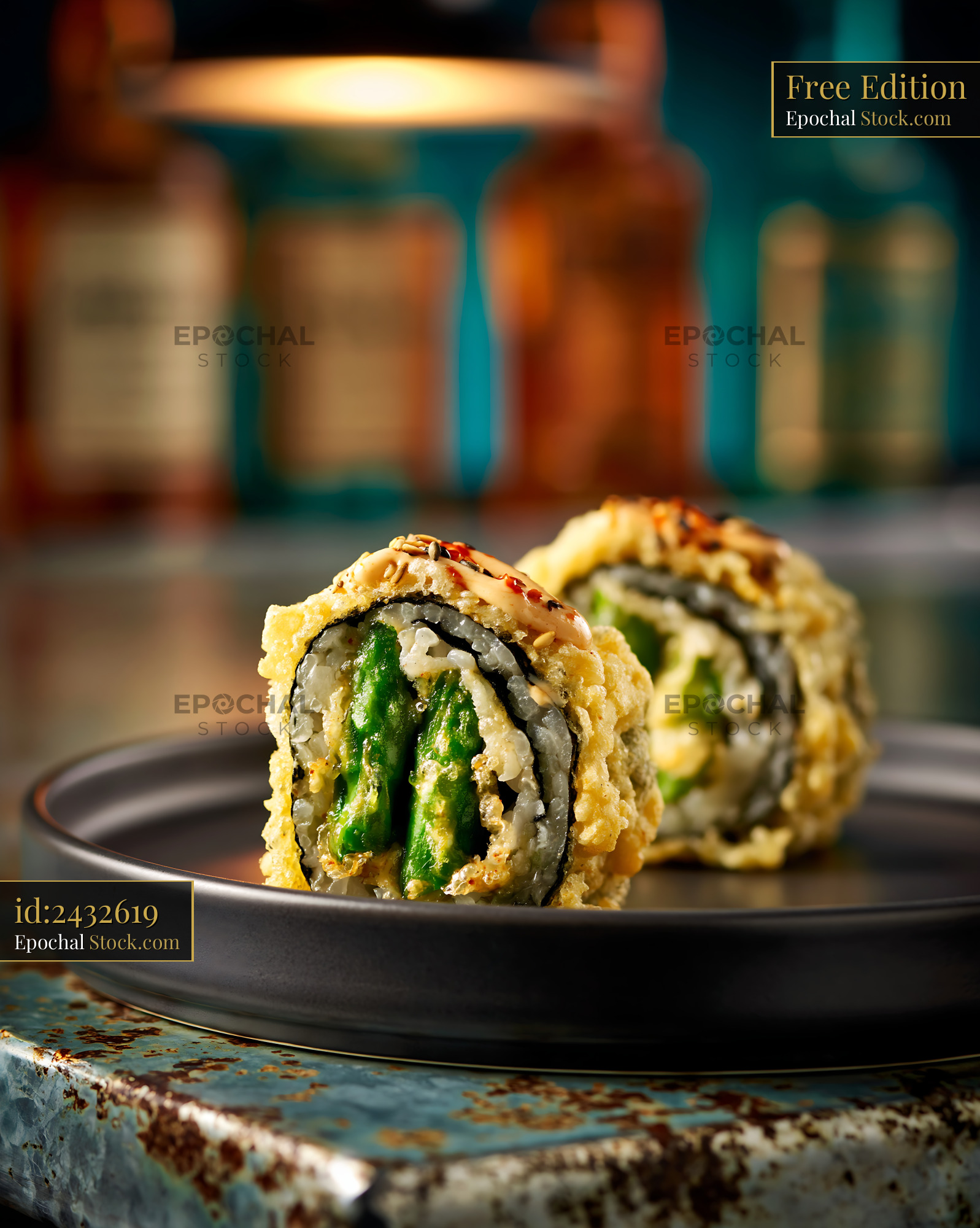 Tempura asparagus sushi rolls with creamy sauce in a moody restaurant - stock photo