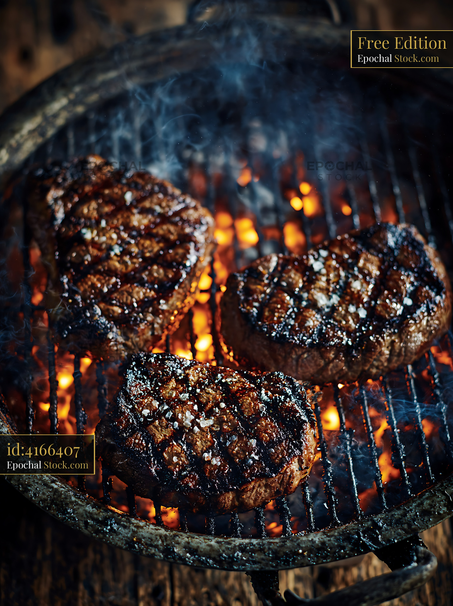 Three beef steaks grilling over hot coals on a barbecue grill - stock photo