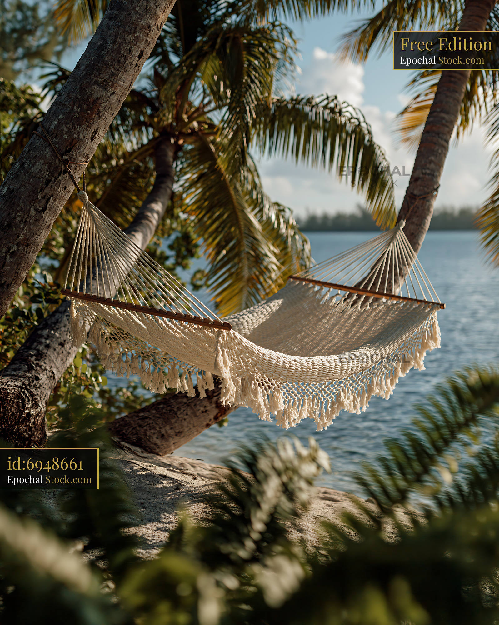 Woven macrame hammock between palm trees on a tropical beach - stock photo