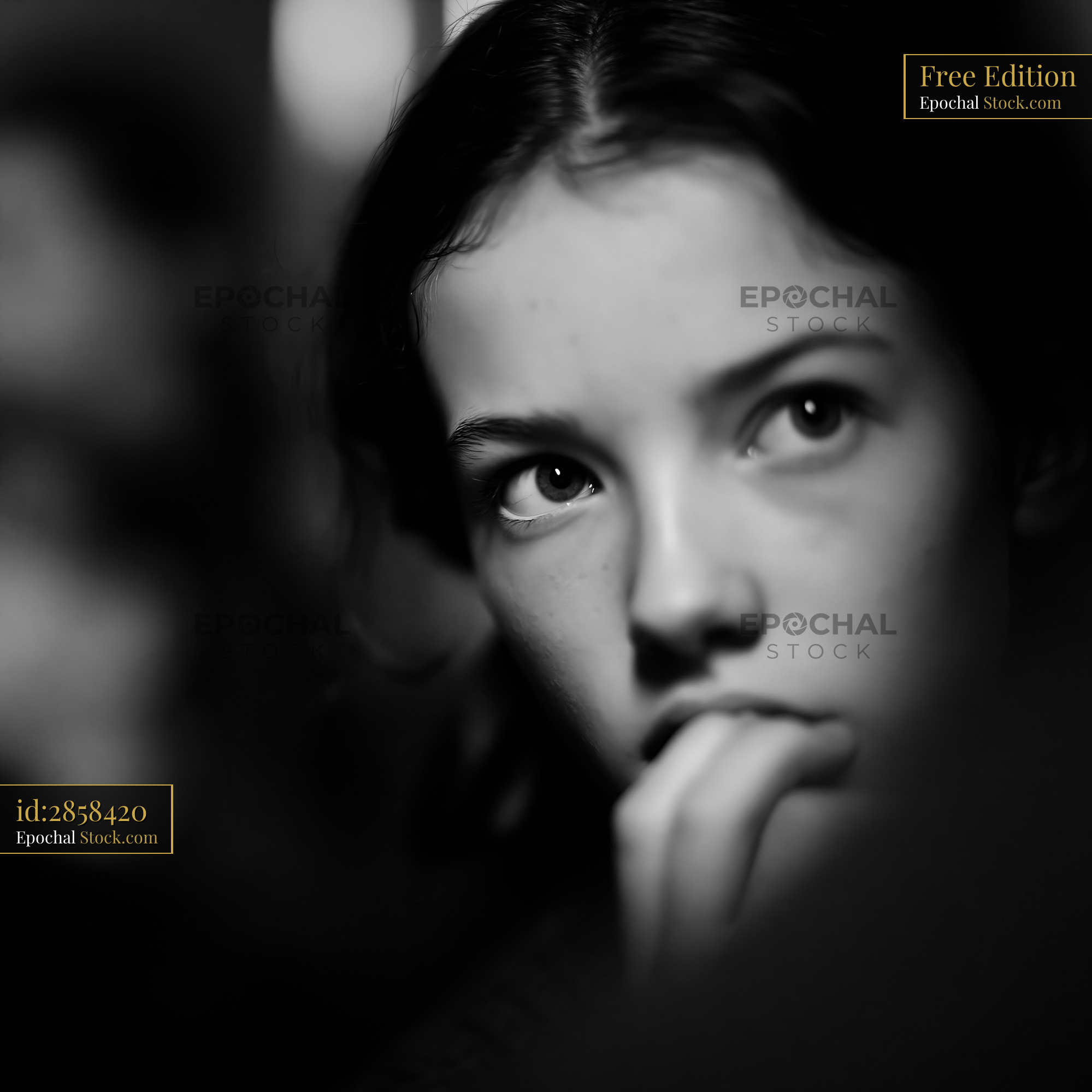 Nervous young girl biting her lip in black and white portrait - stock photo