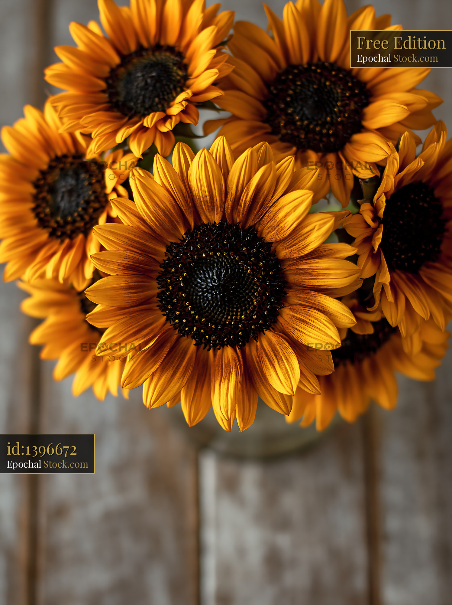 Vibrant sunflower bouquet in a glass vase on a rustic wooden table - stock photo