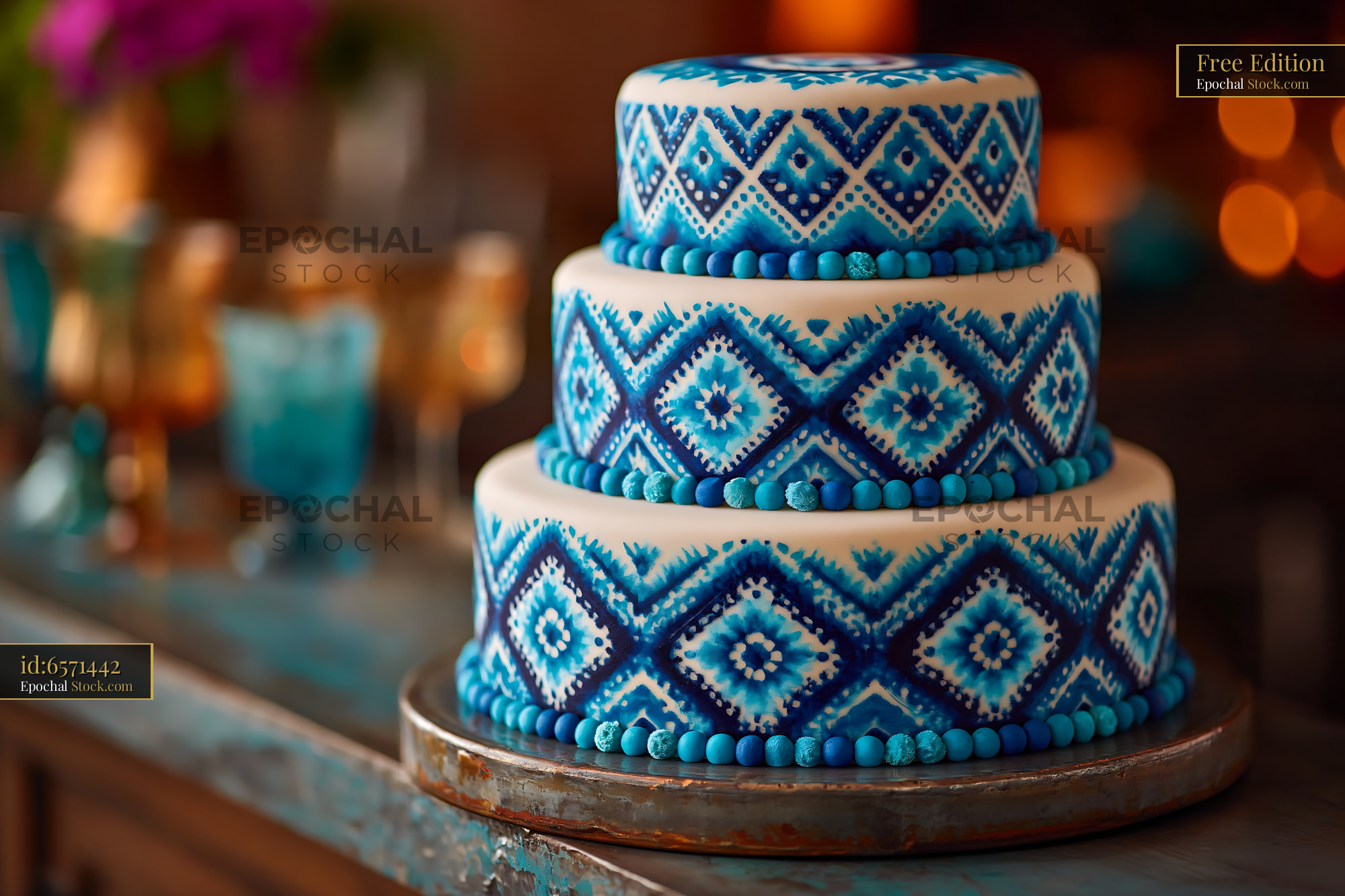 Three-tiered white cake with blue geometric ikat patterns - stock photo