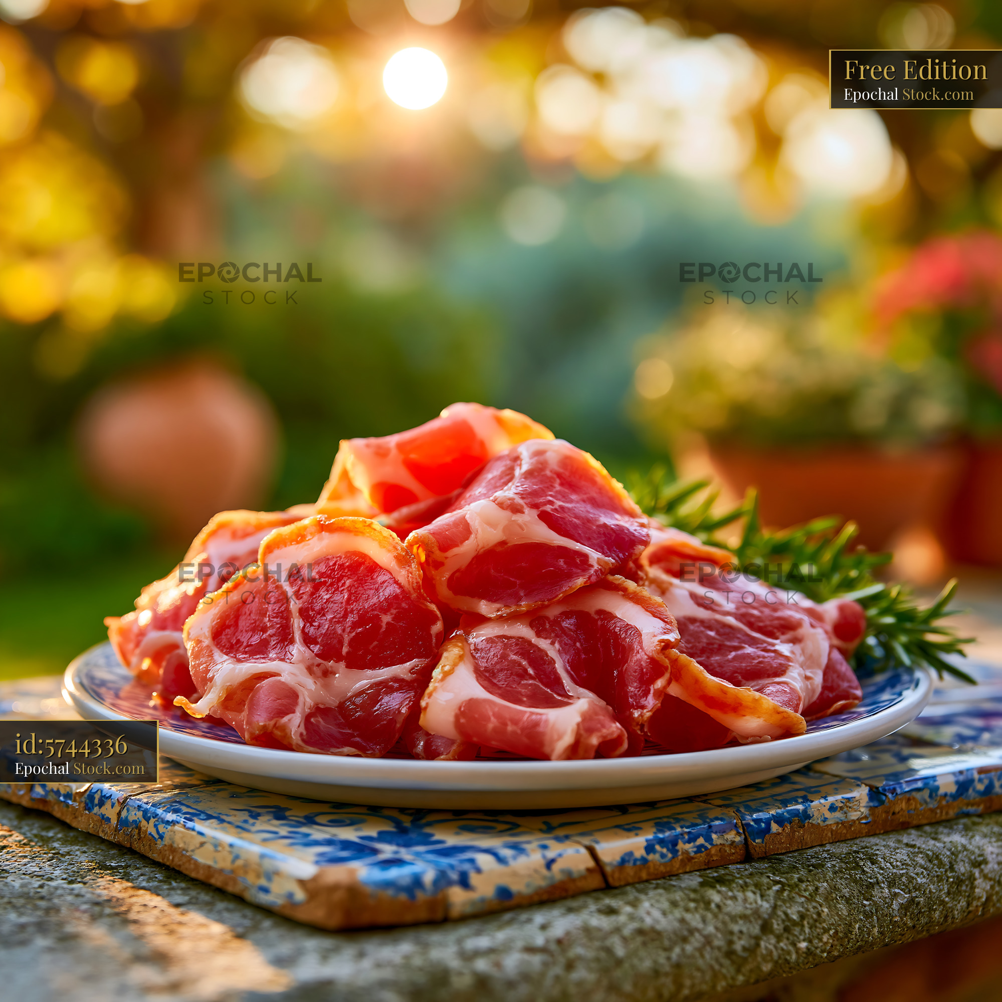 Thinly sliced culatello di zibello meat on a ceramic plate outdoors - stock photo