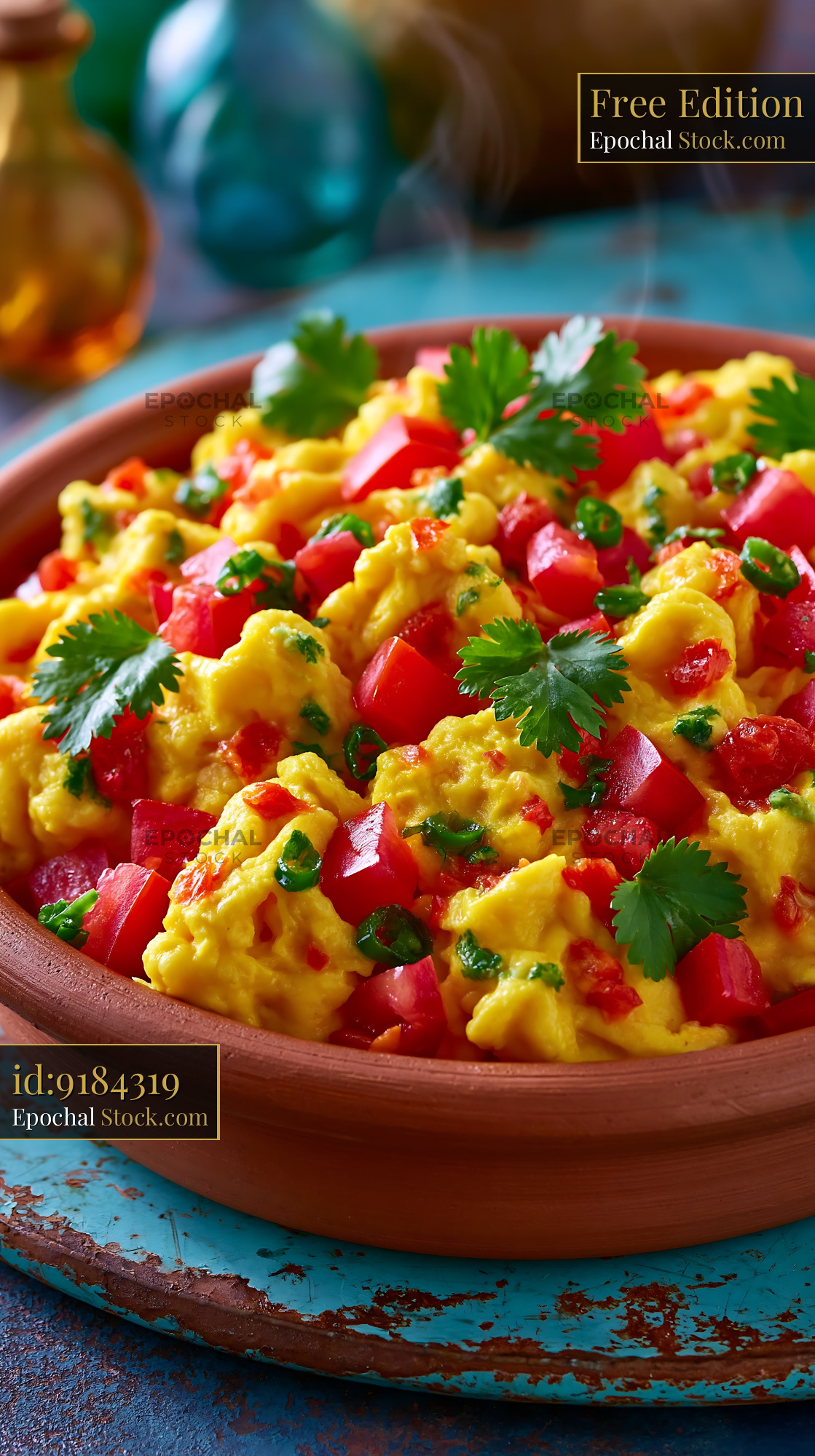Akuri egg food with tomatoes and cilantro in a rustic clay bowl - stock photo