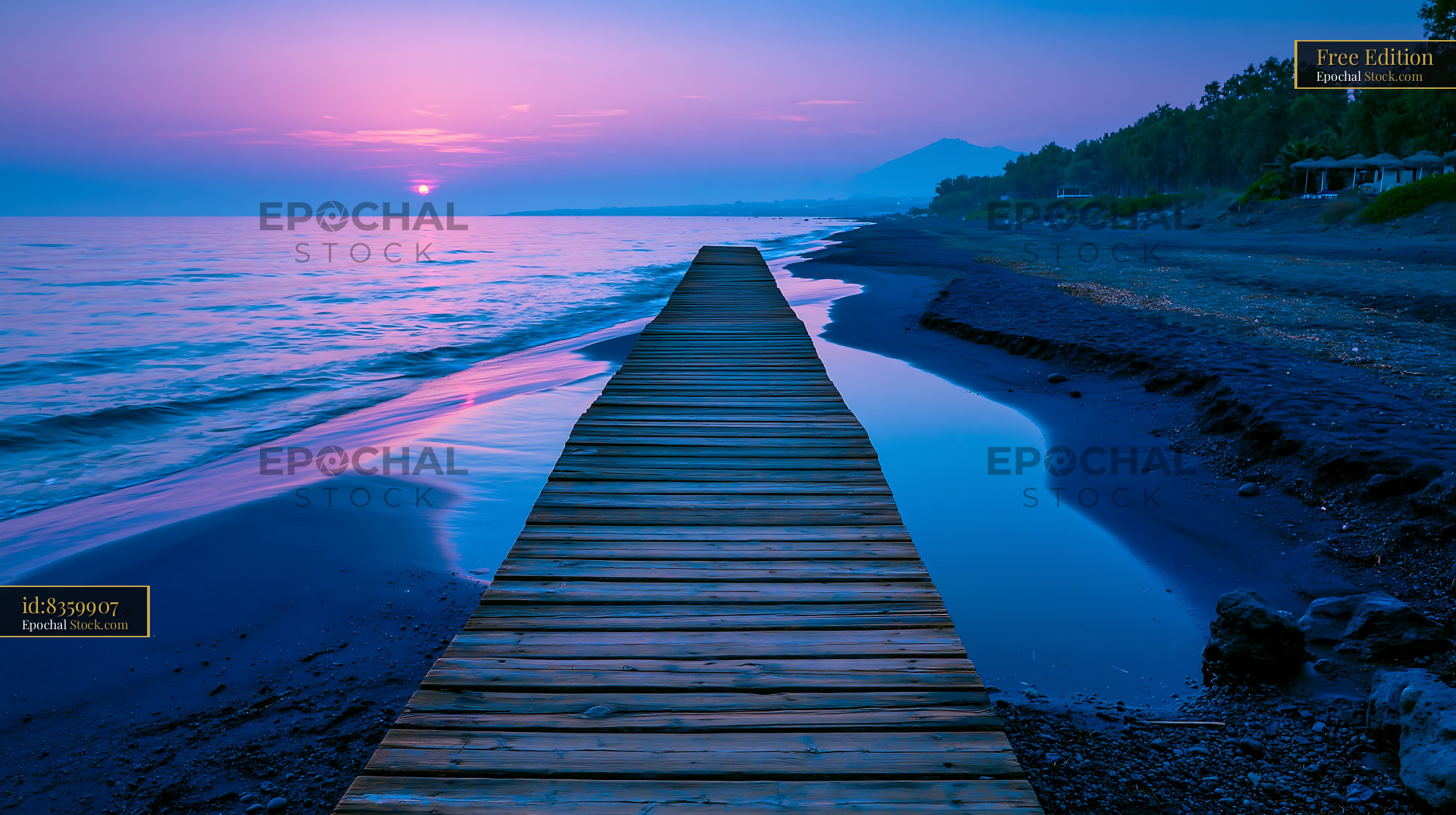 Wooden pier leading into the sea during a vibrant purple sunset - stock photo