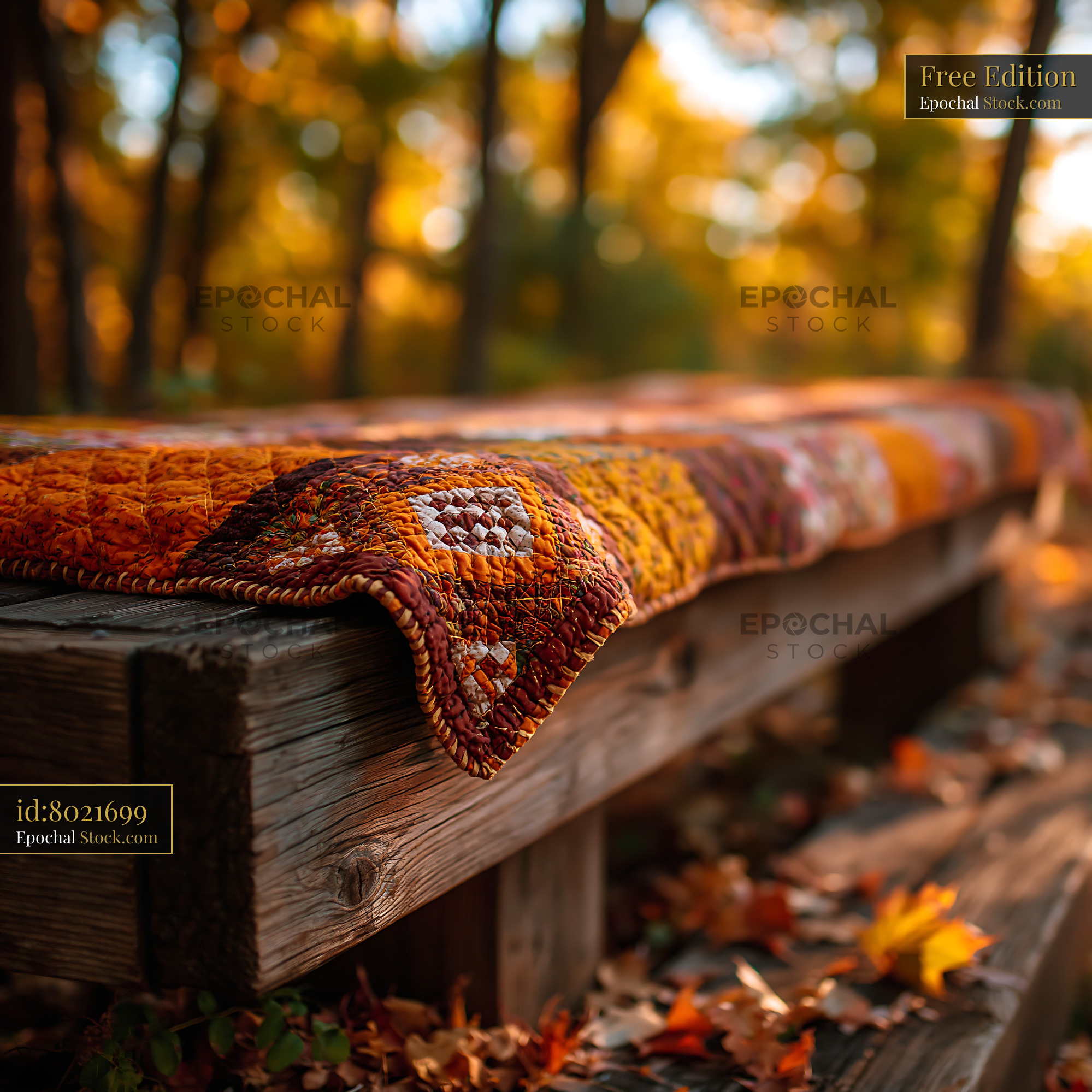 Colorful patchwork quilt on a rustic wooden seat in autumn forest - stock photo