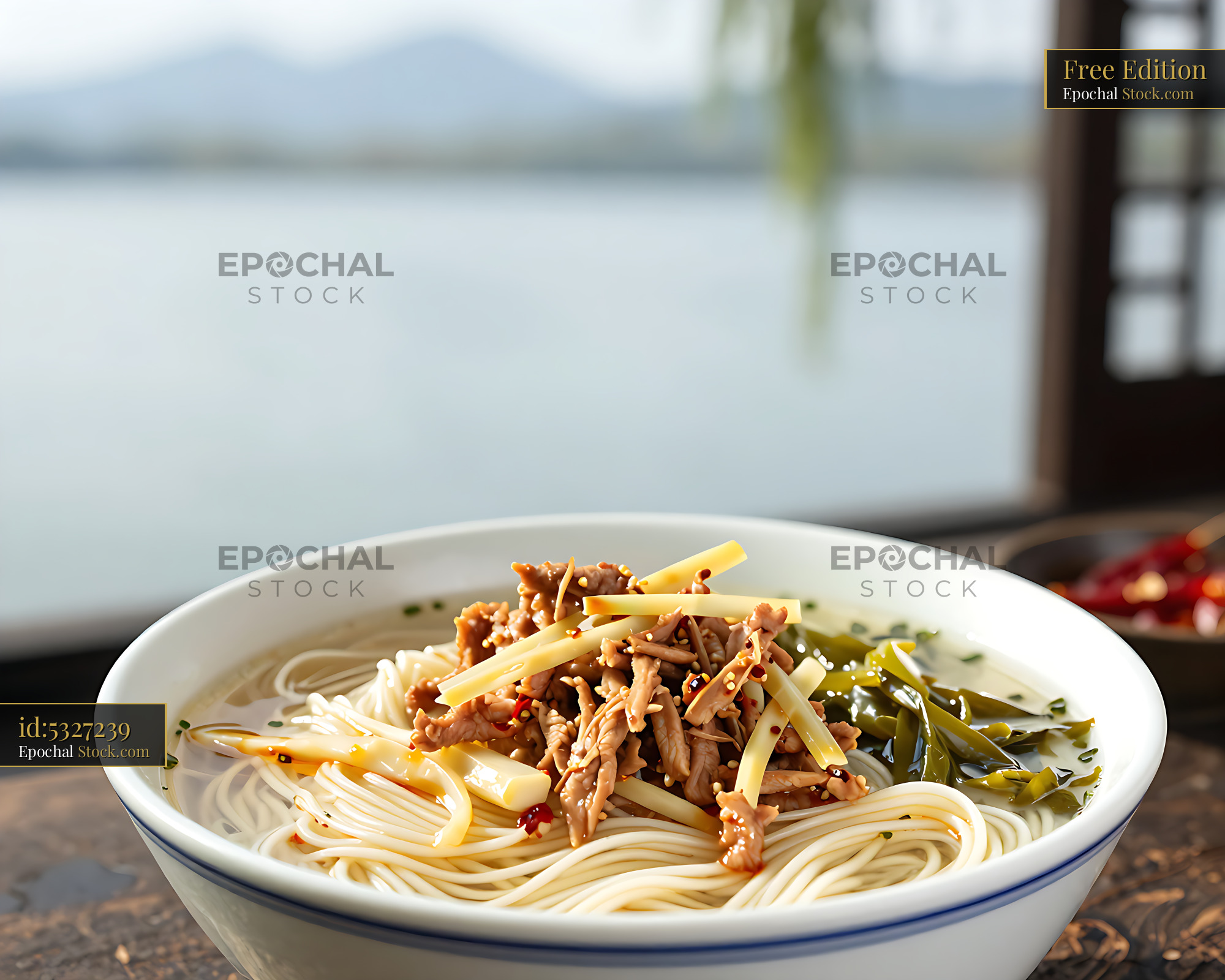 Bowl of Hangzhou Pian Er Chuan noodle soup served by a scenic lake - stock photo