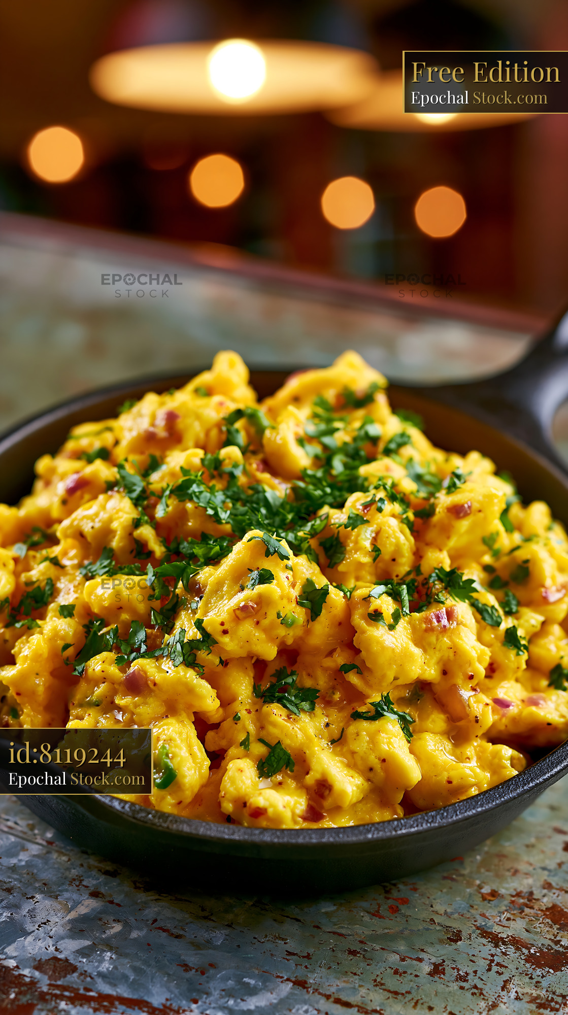 Spicy egg bhurji with fresh herbs and onions in a cast iron skillet - stock photo