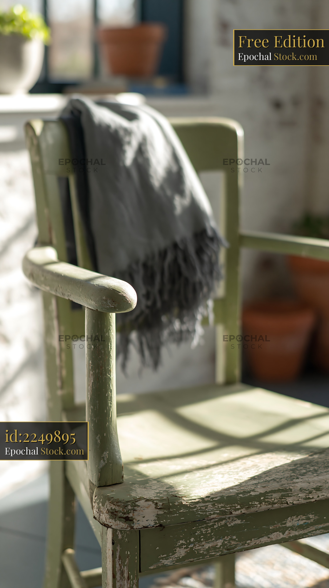 Rustic green wooden chair with grey fringed throw blanket in sunlit ro - stock photo