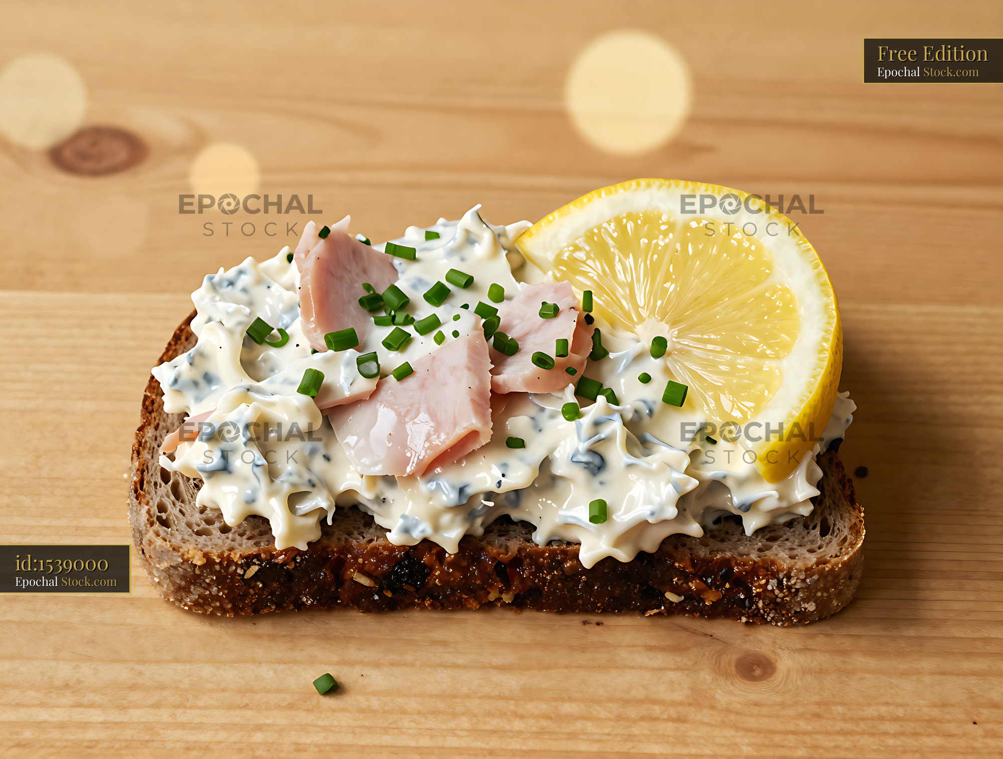 Danish skinkesalat on dark rye bread with chives and lemon slice - stock photo