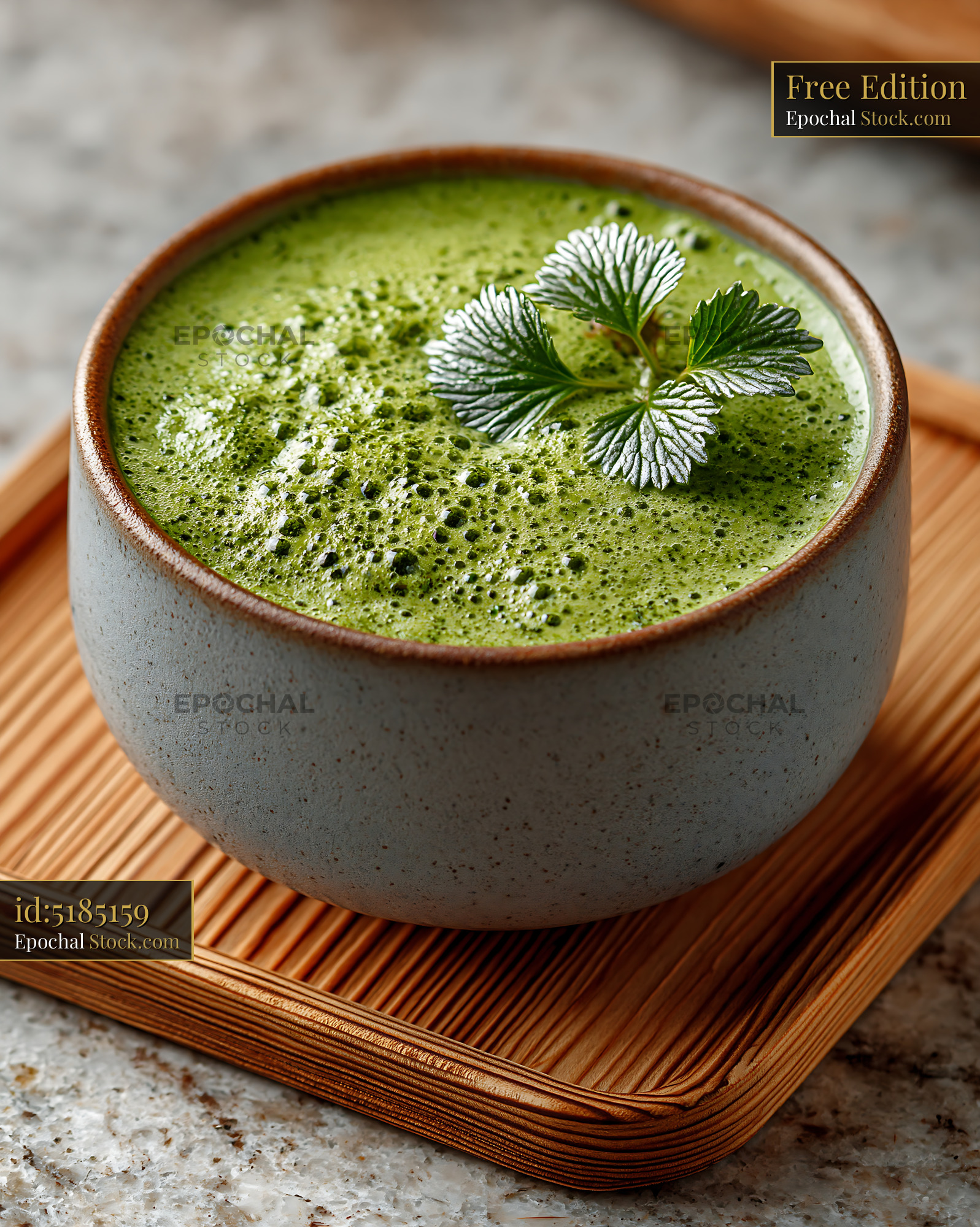 Fresh green mugwort herb smoothie with froth in a rustic ceramic cup - stock photo