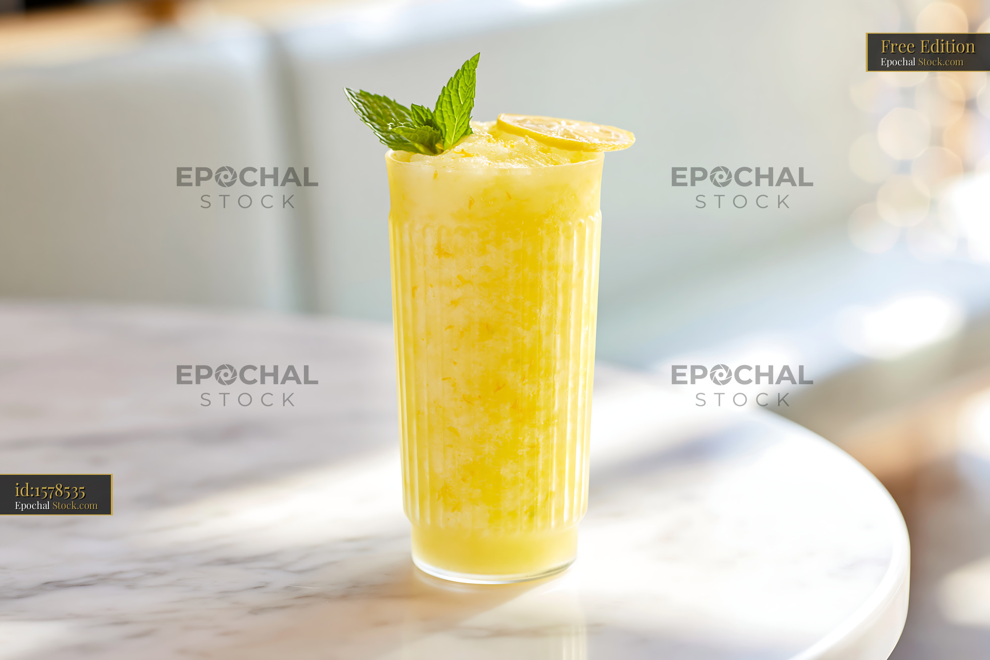 Yuja citron smoothie with mint garnish on a marble table in sunlight - stock photo