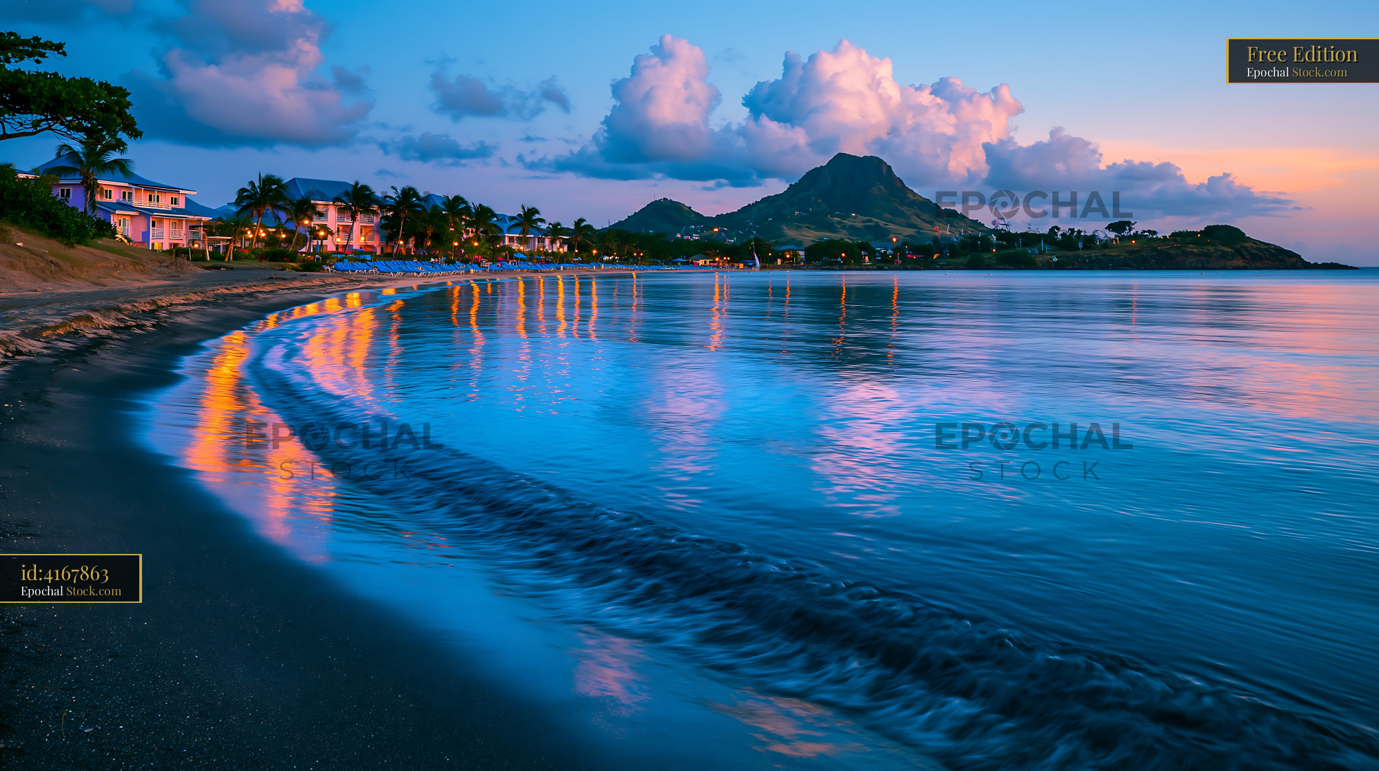 Tropical beach resort at sunset with mountain view and reflections