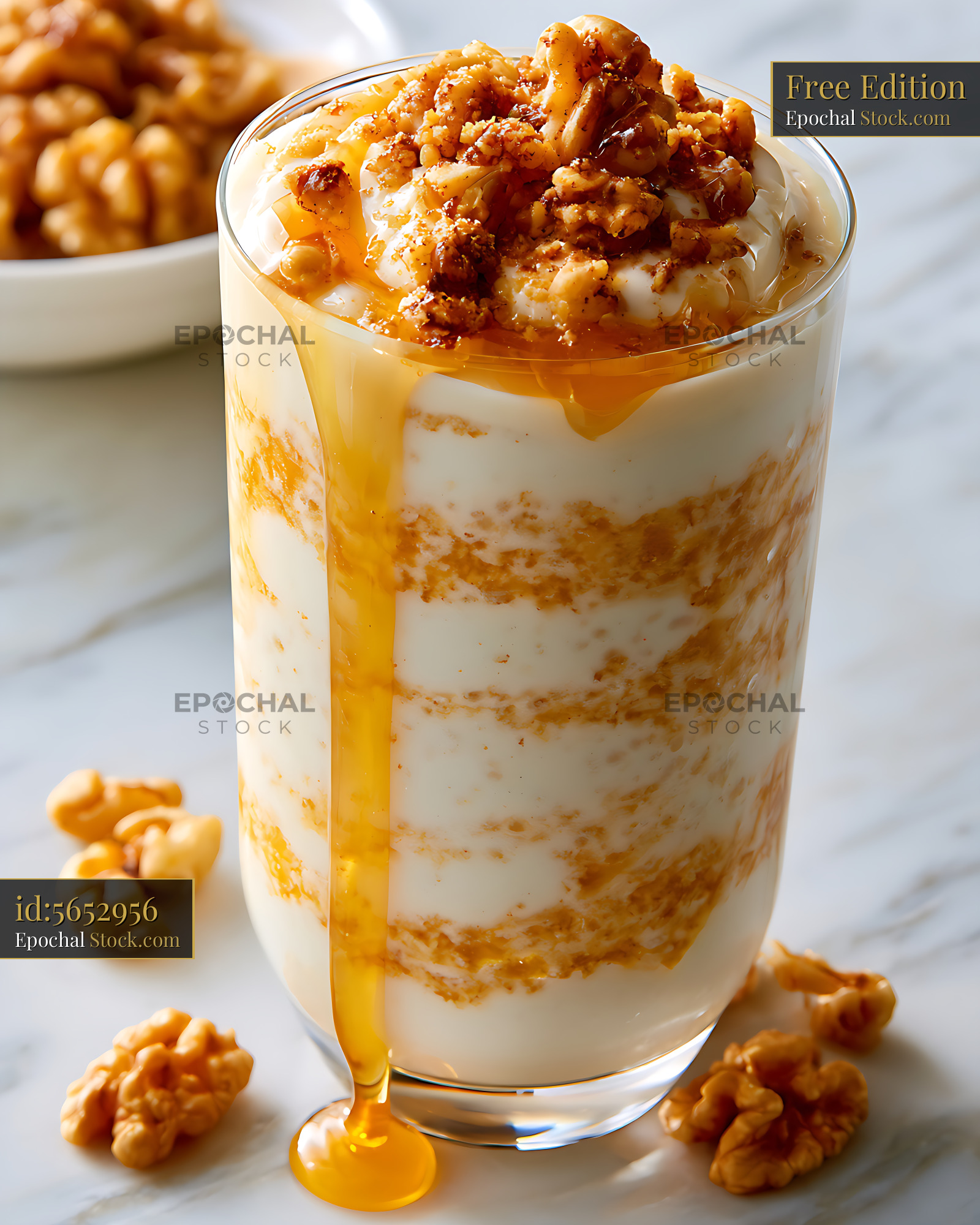 Greek honey yogurt smoothie with crushed walnuts on marble surface - stock photo