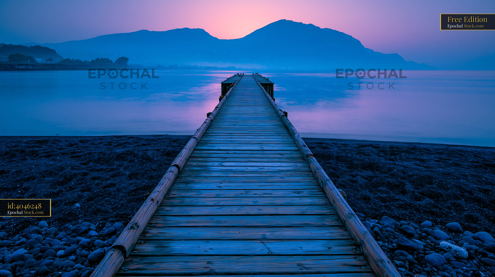 Wooden pier extending into calm sea during purple twilight - stock photo