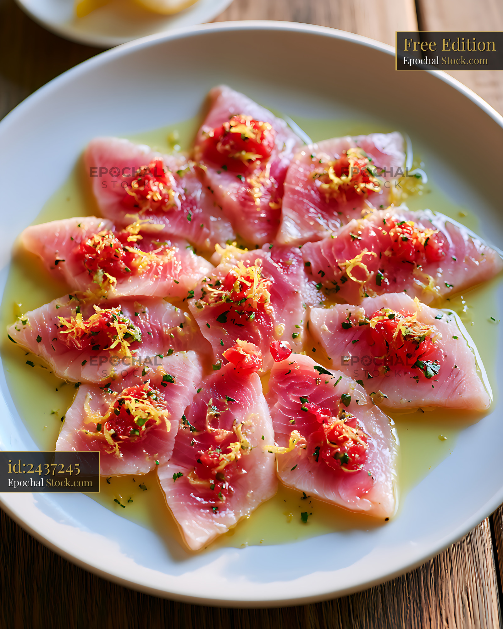Swordfish carpaccio with lemon zest and olive oil on a white plate - stock photo