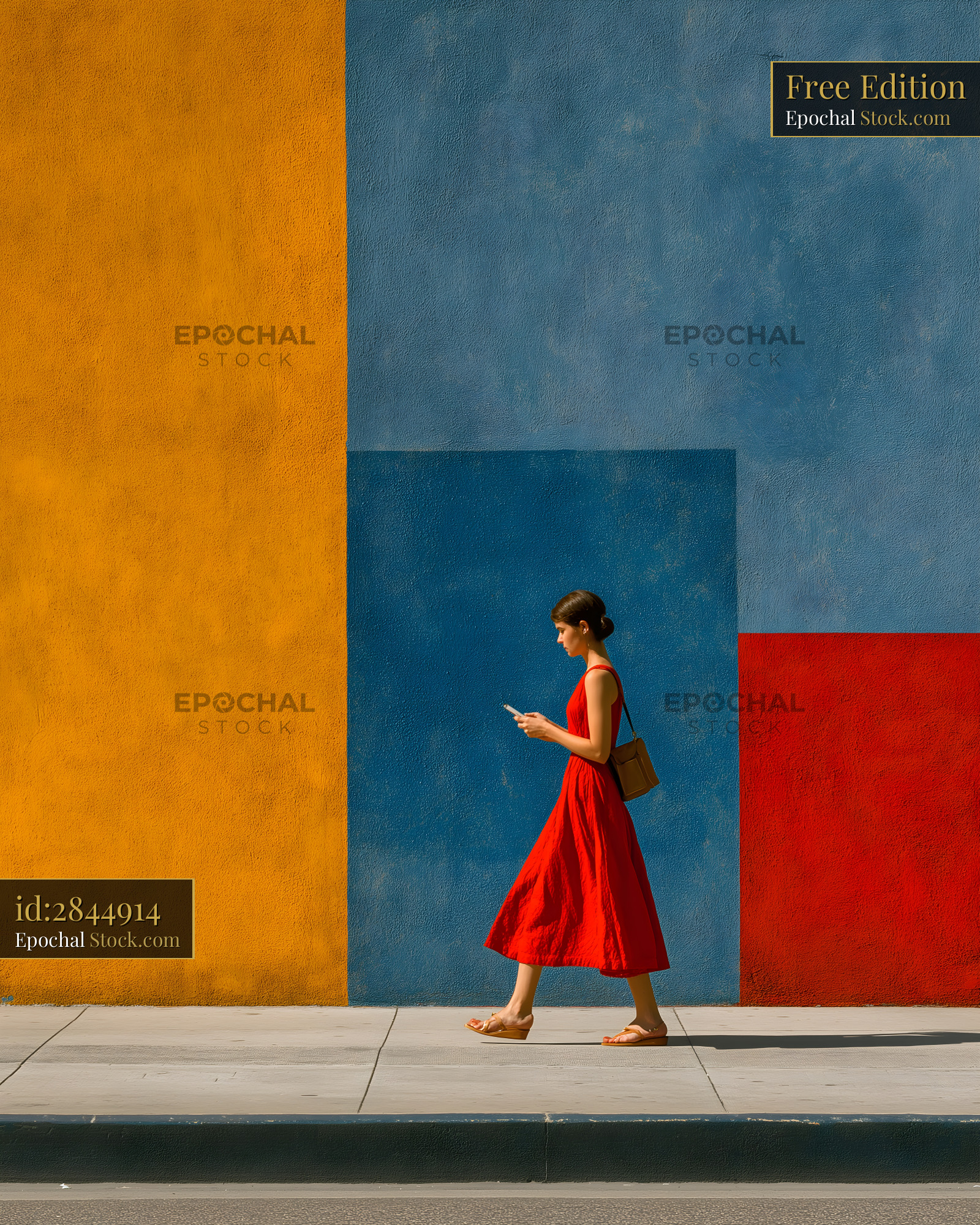 Woman walking by colorful wall while using her phone Free Premium Stock Image