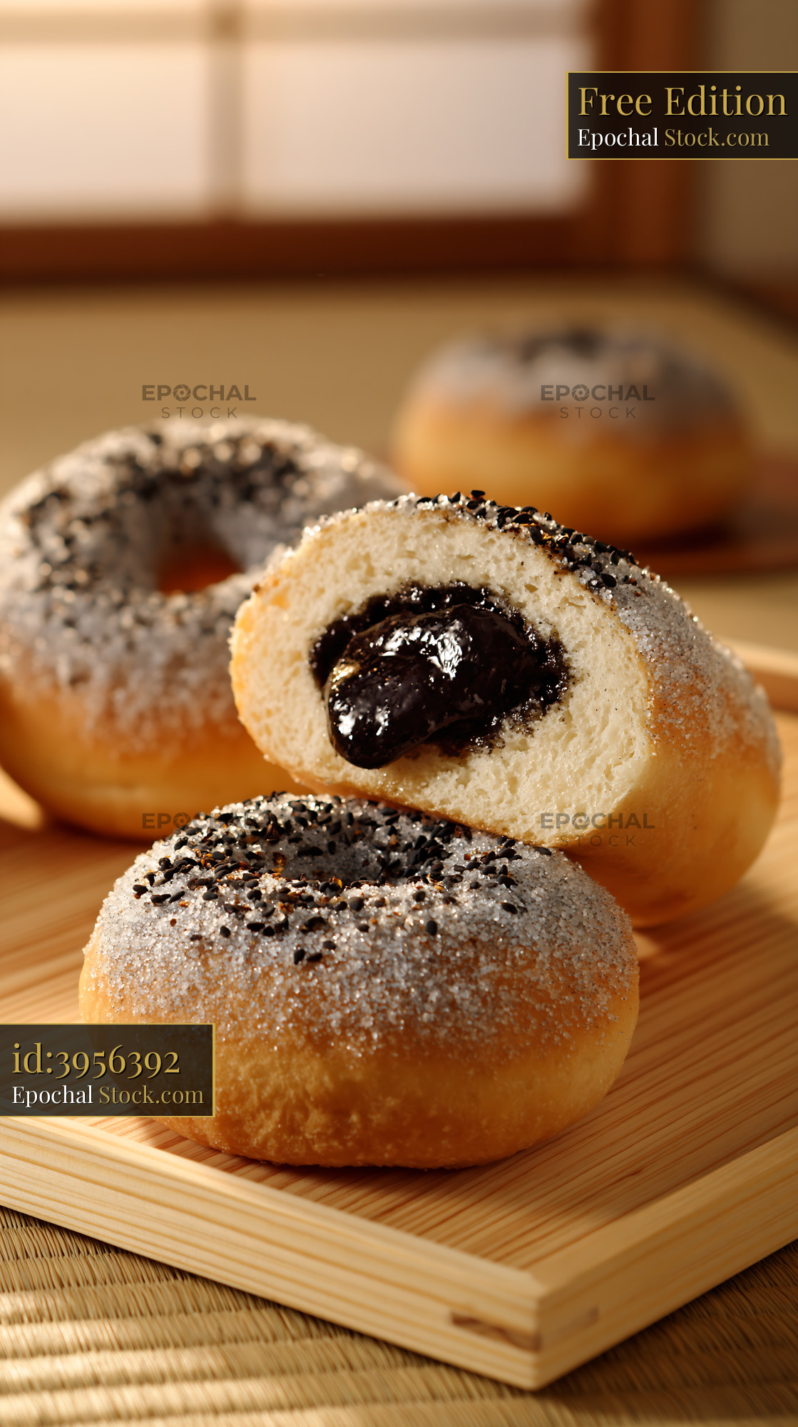 Sugar coated donuts with black sesame filling on a wooden tray - stock photo
