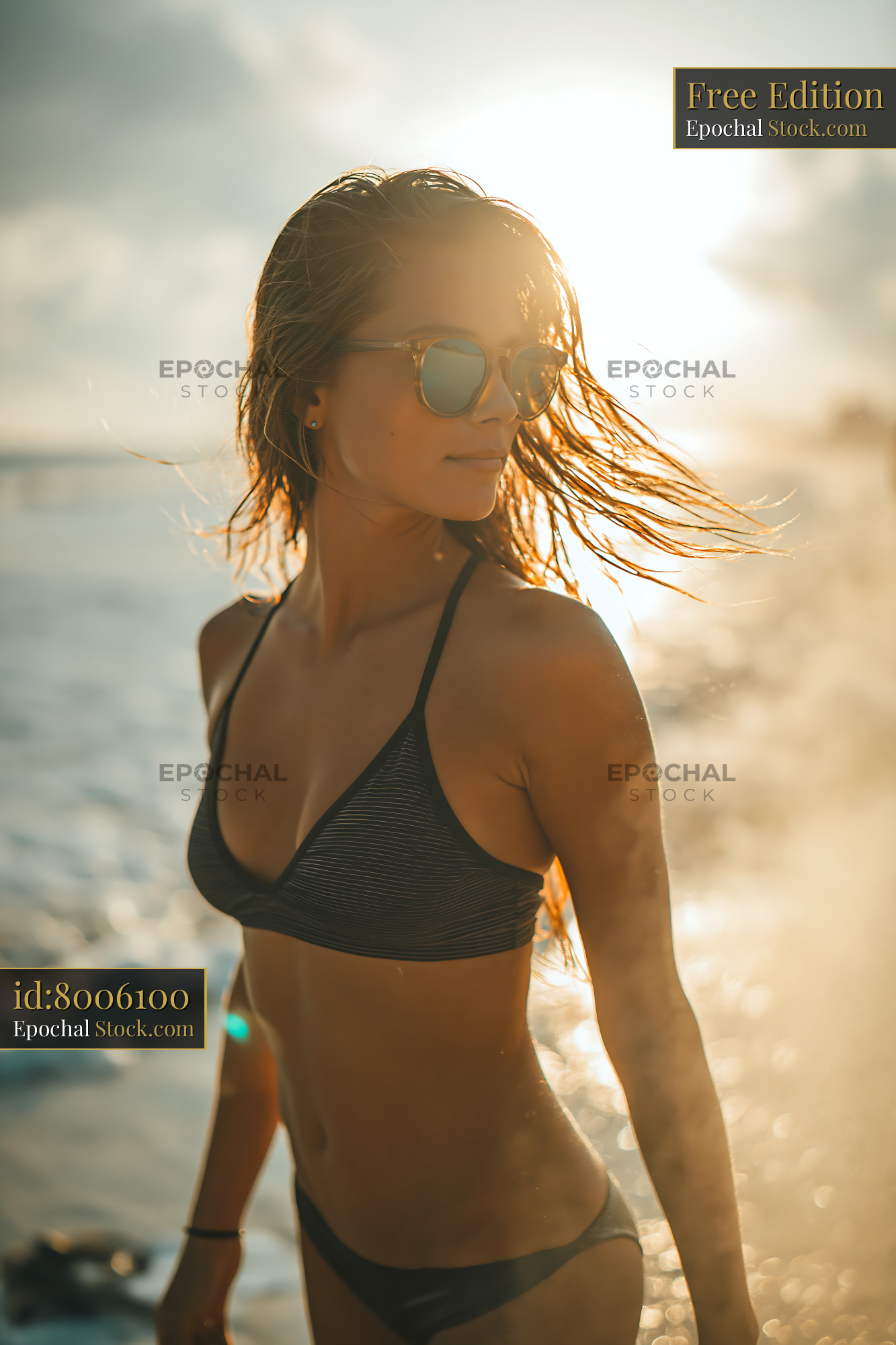 Young woman in bikini enjoying golden hour at the beach - stock photo