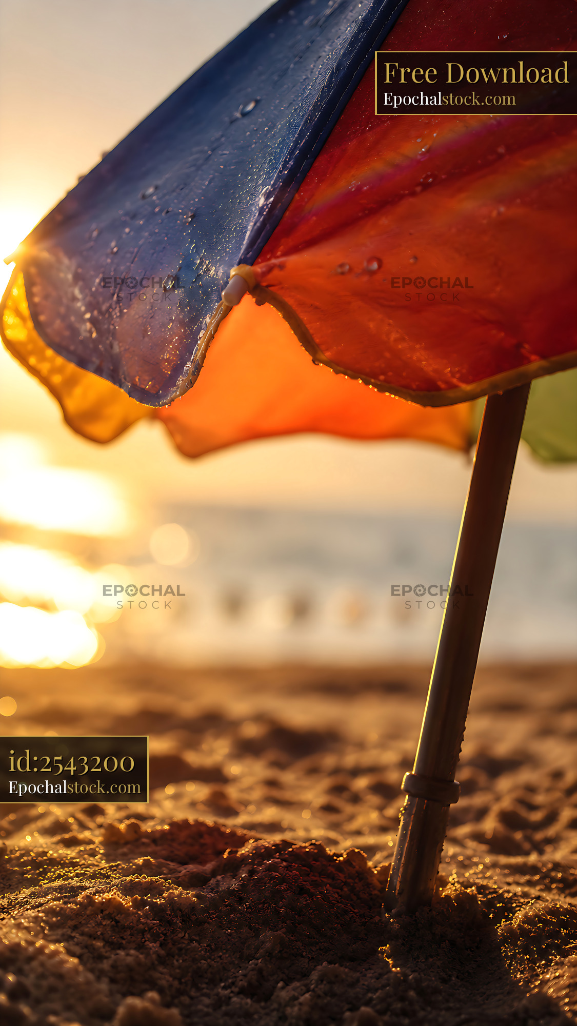 Watermarked full-resolution preview of Colorful beach umbrella at sunset on sandy shore