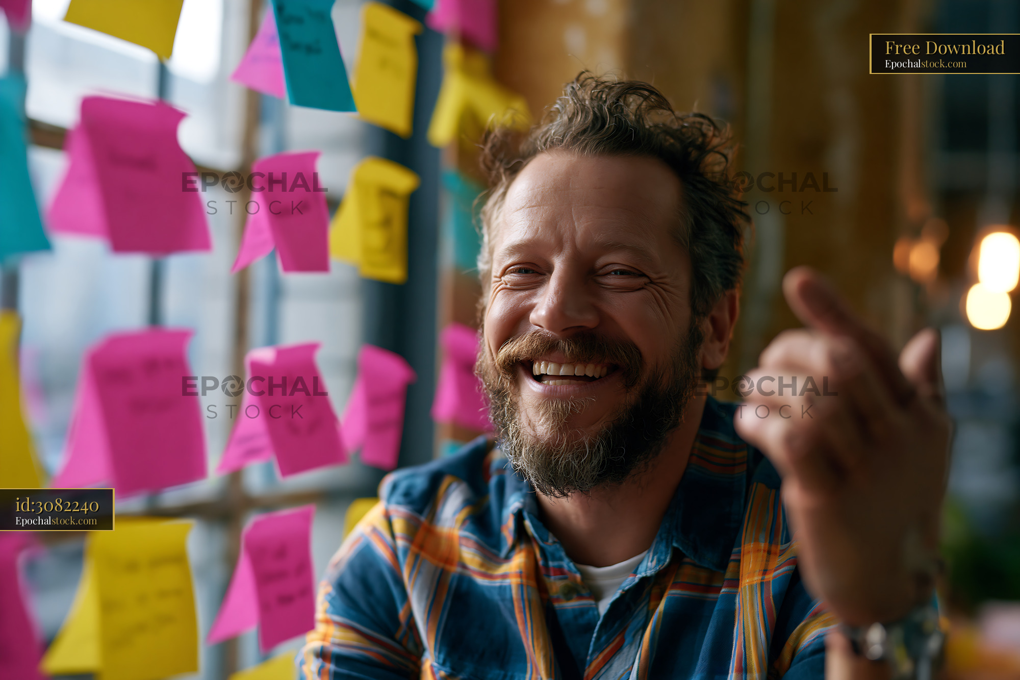 Watermarked full-resolution preview of Man smiling in an office filled with colorful sticky notes