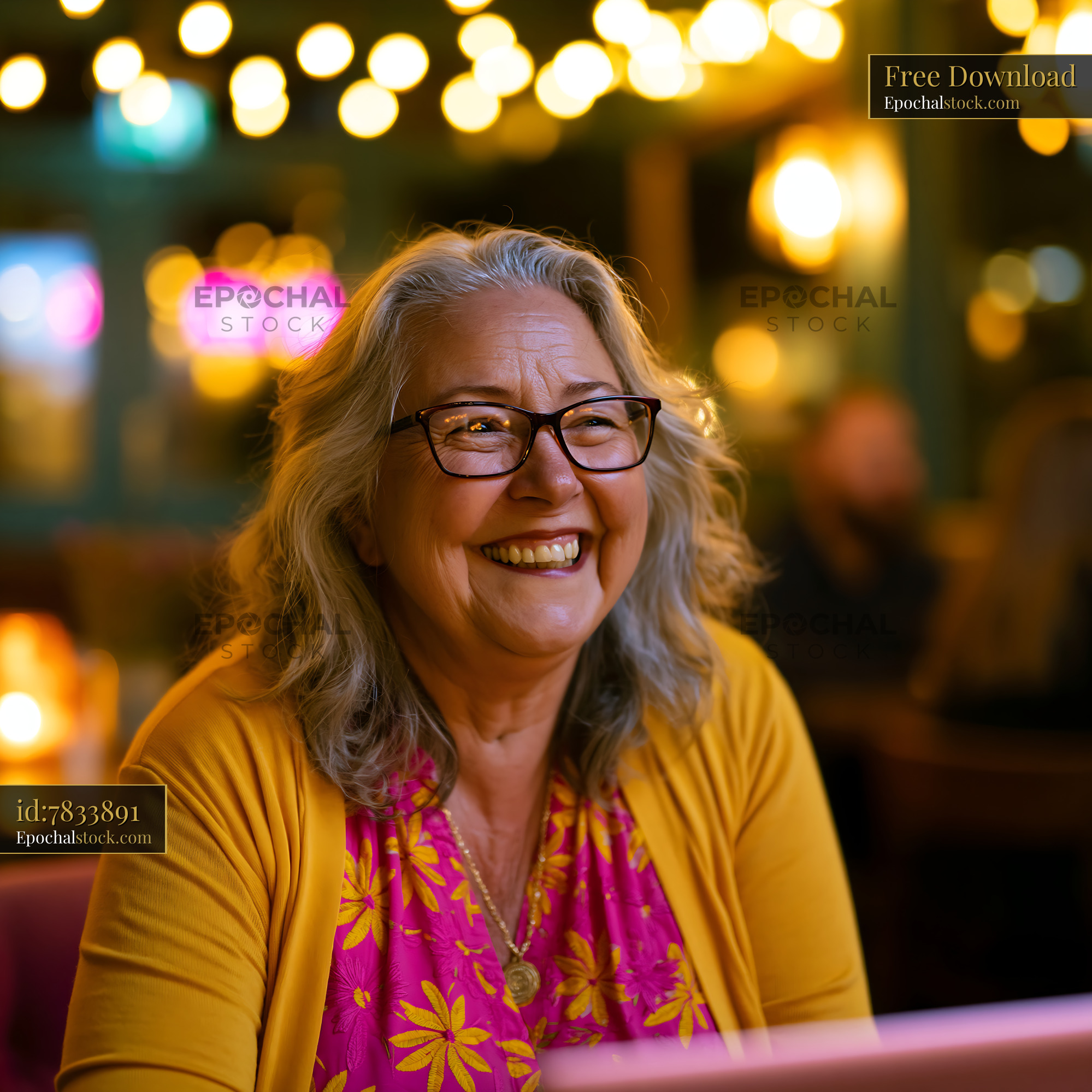 Watermarked full-resolution preview of Smiling woman with glasses sitting in a cafe with warm lights