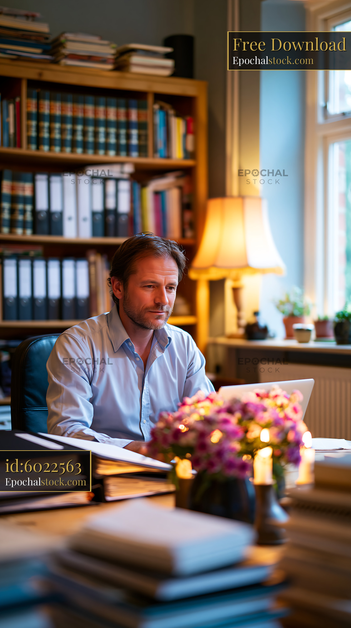 Watermarked full-resolution preview of Man working at a desk in a cozy office with books and plants