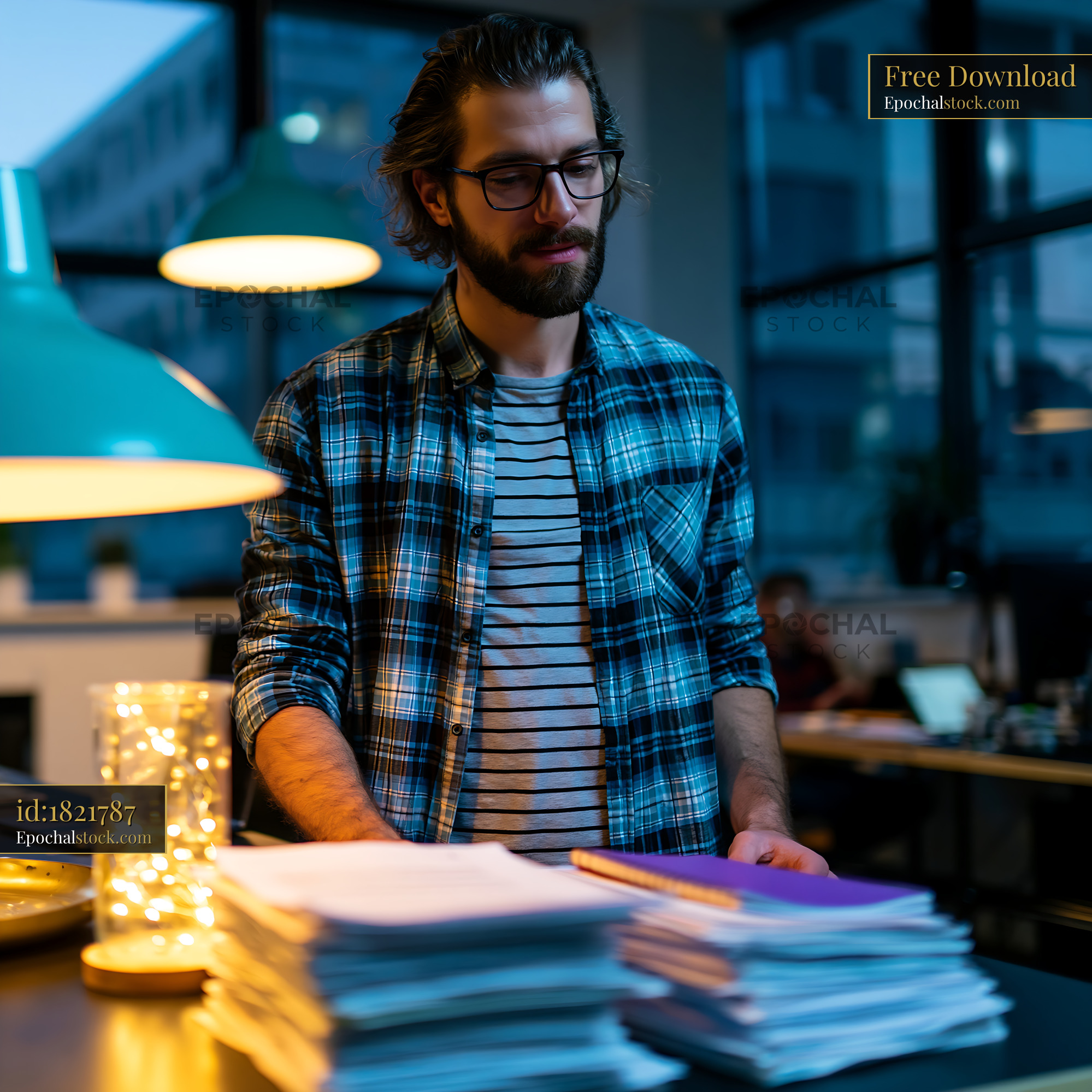Watermarked full-resolution preview of Man working at a desk in an office during the evening