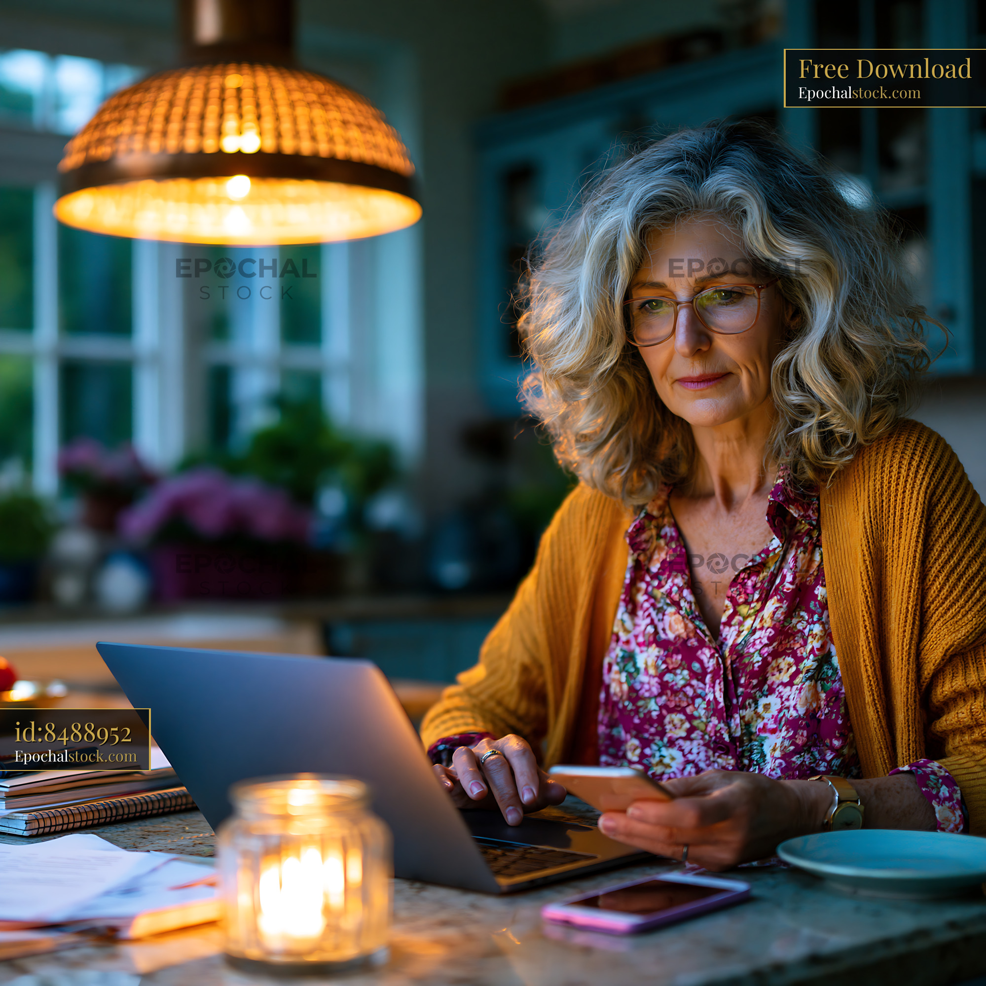 Watermarked full-resolution preview of Woman working on a laptop in a cozy kitchen at night