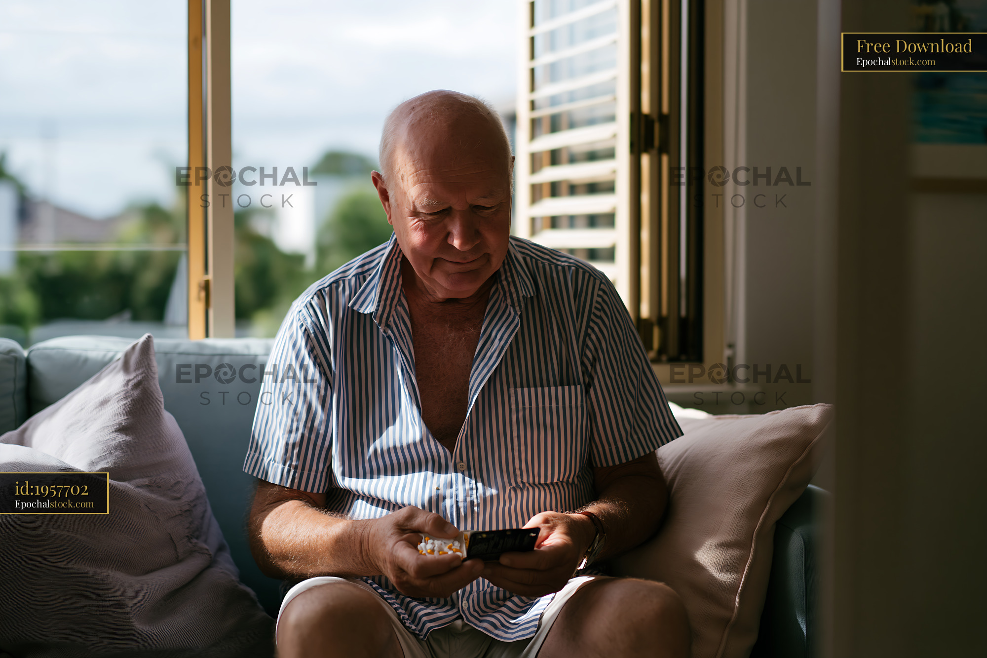 Watermarked full-resolution preview of Man sitting on couch using smartphone indoors