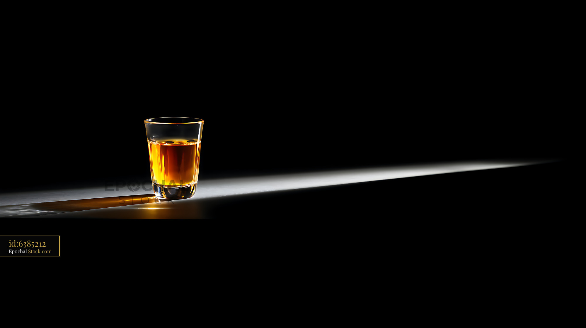 Whiskey Glass in Dramatic Spotlight Lighting - stock photo