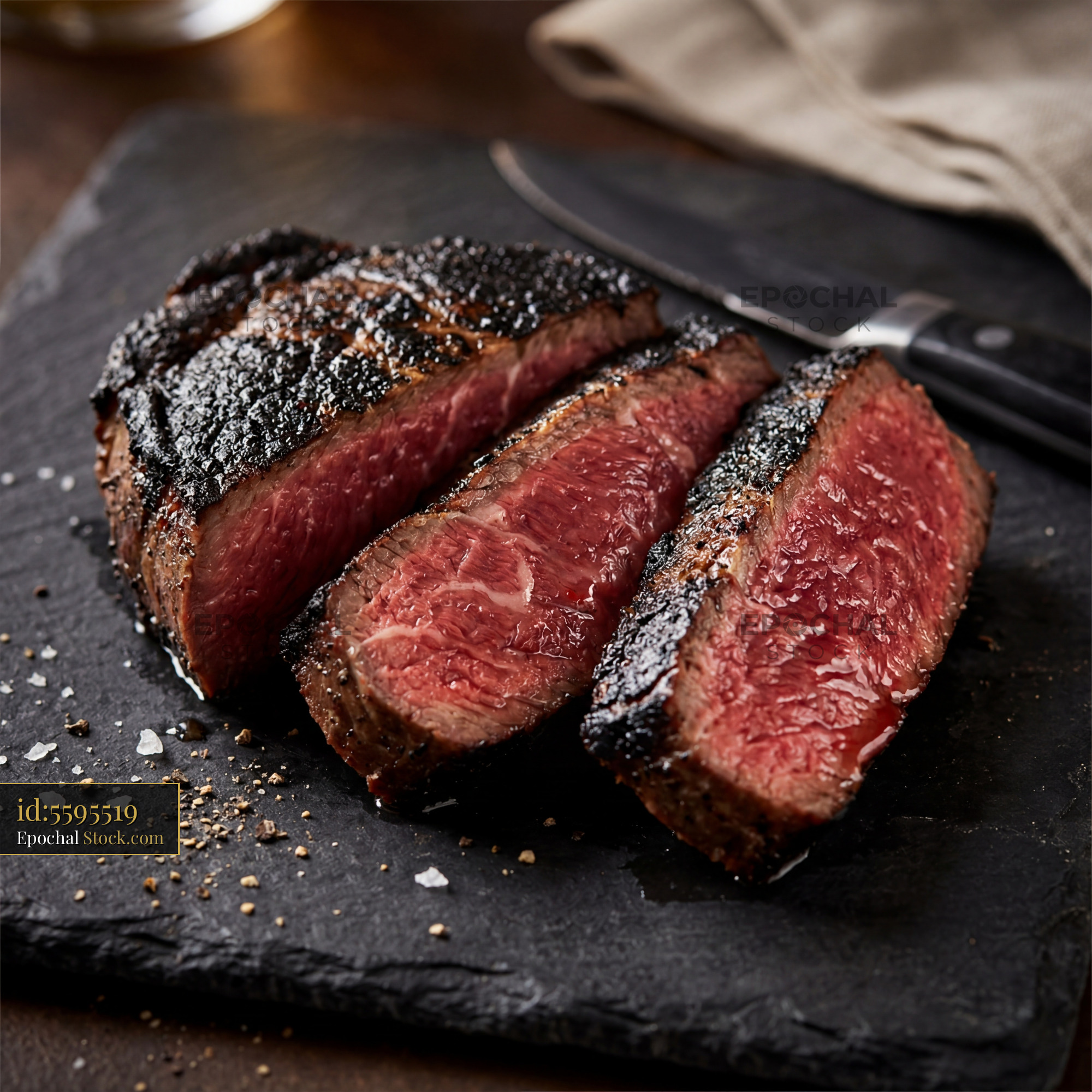 Medium-Rare Steak Sliced on Black Slate - stock photo