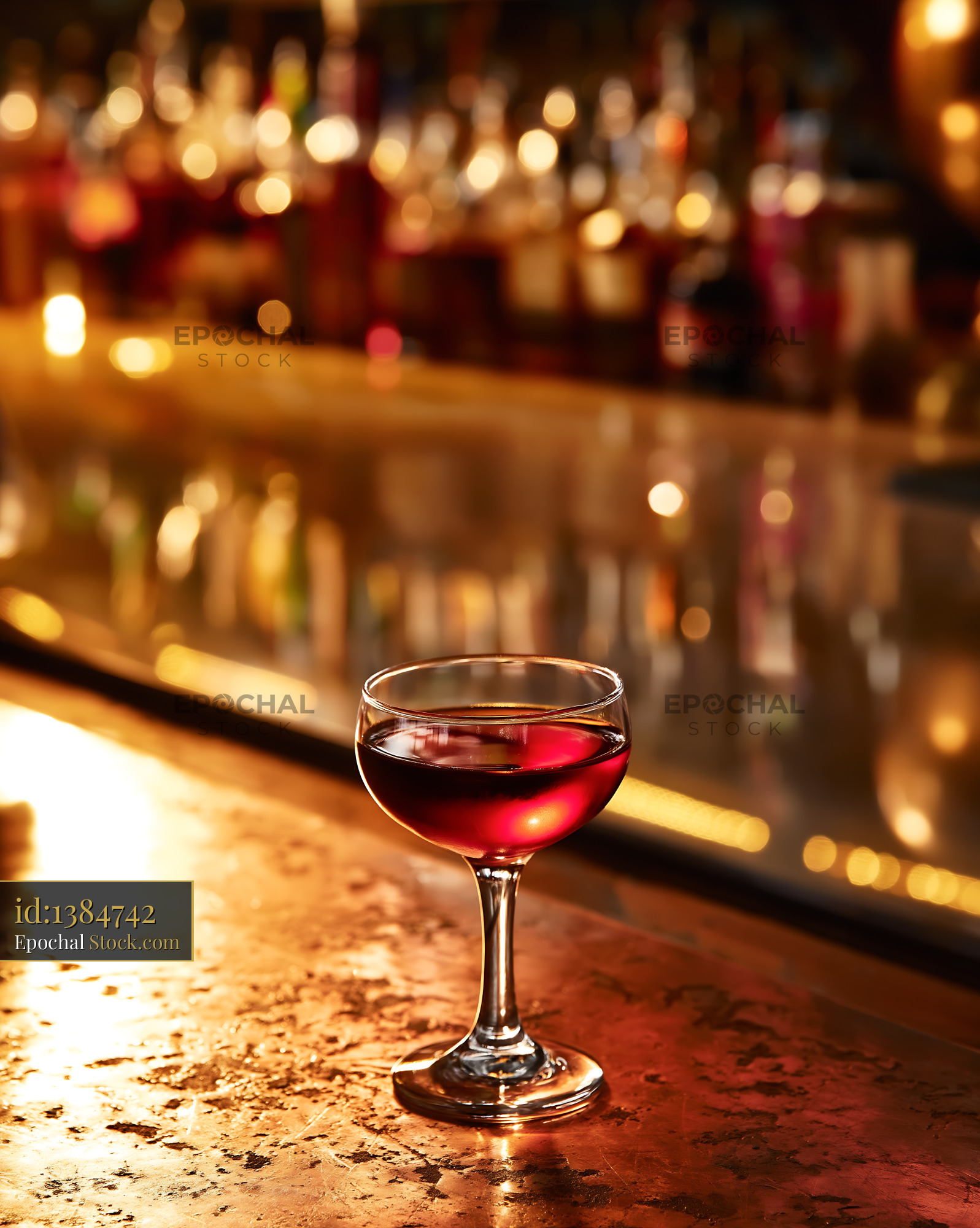 Red Wine Glass on Bar Counter with Warm Golden Lights - stock photo