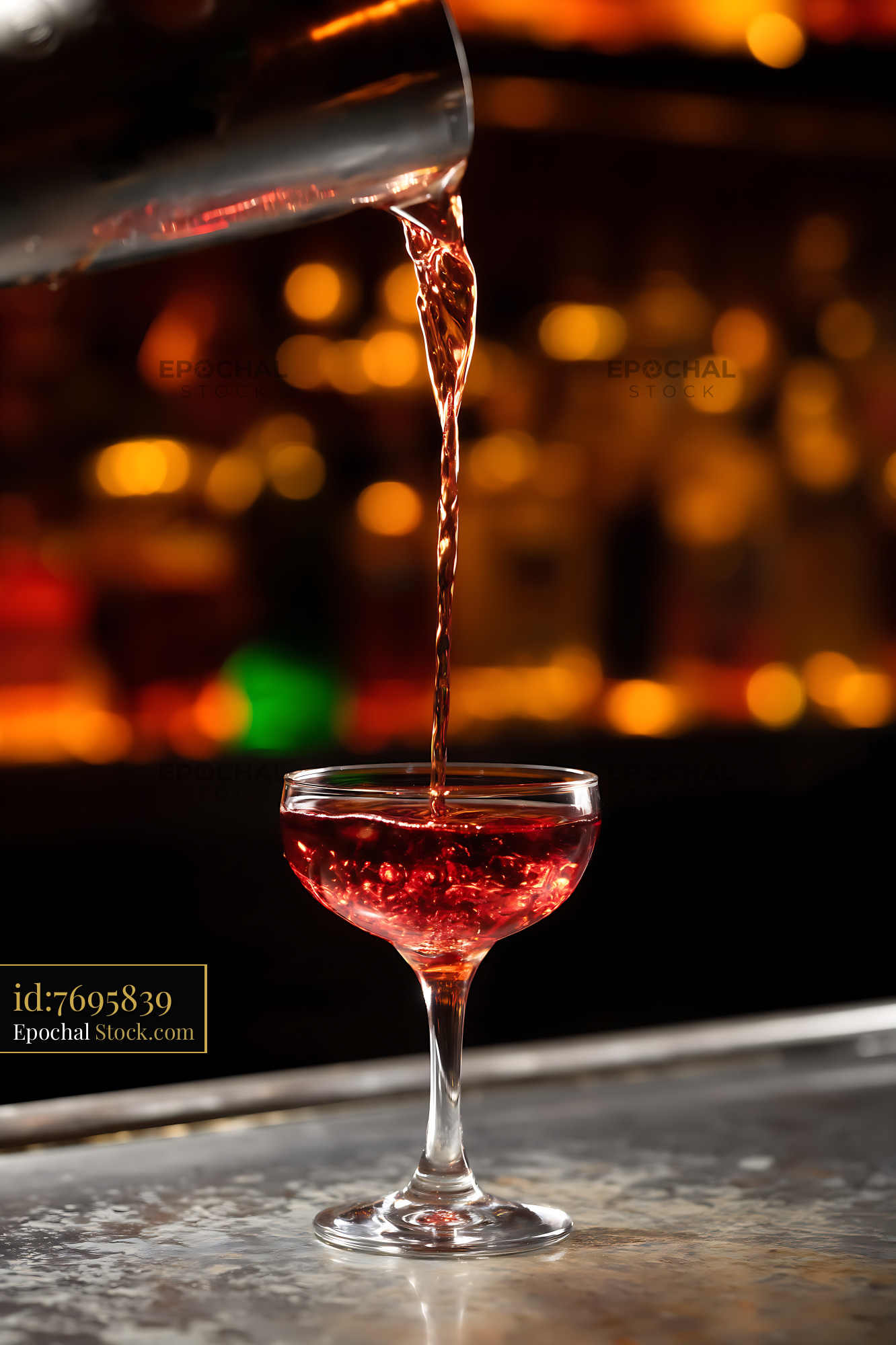 Red Cocktail Pouring Into Coupe Glass - stock photo
