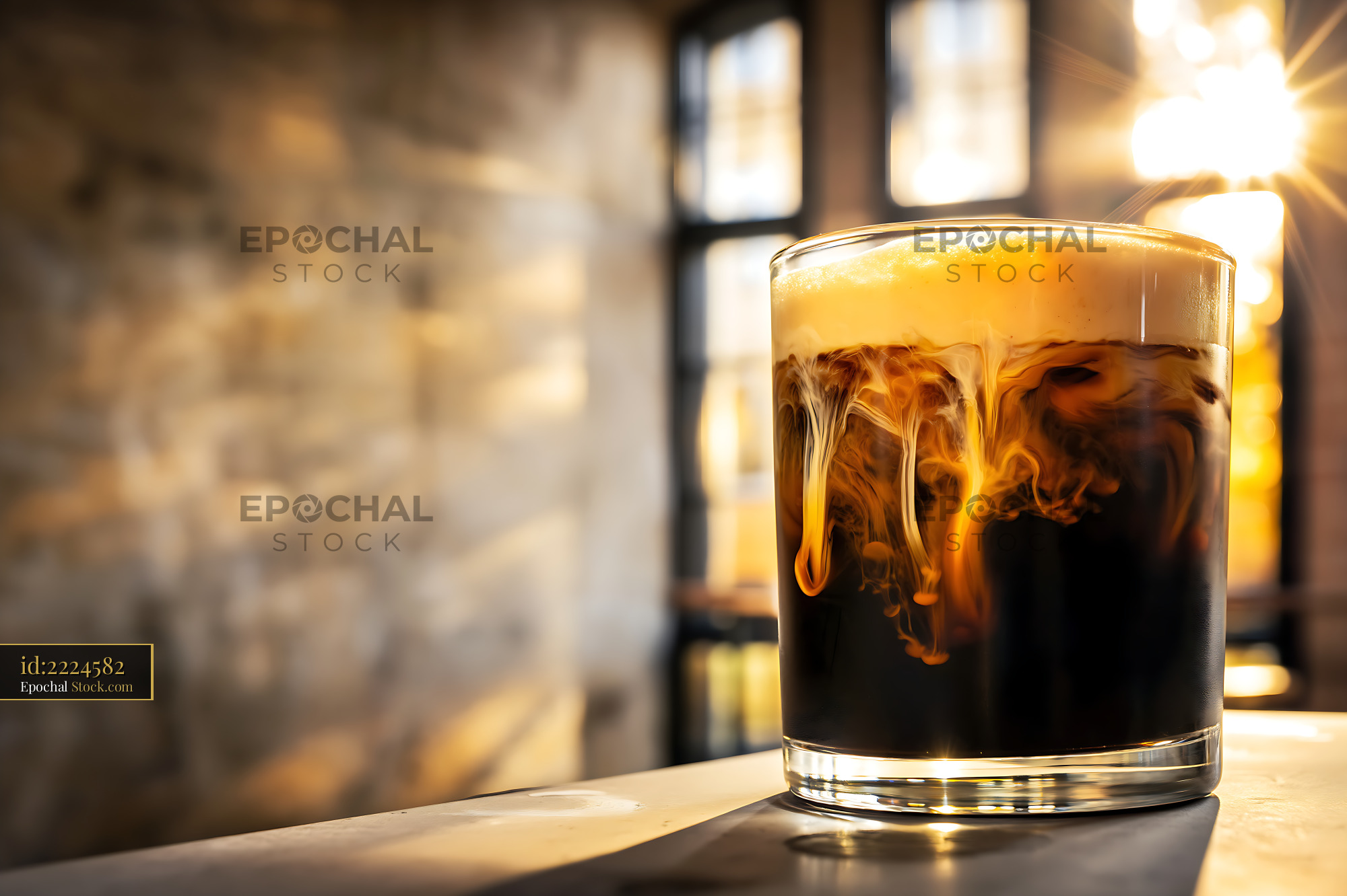 Nitro Caramel Coffee with Ice in Sunlit Cafe - stock photo