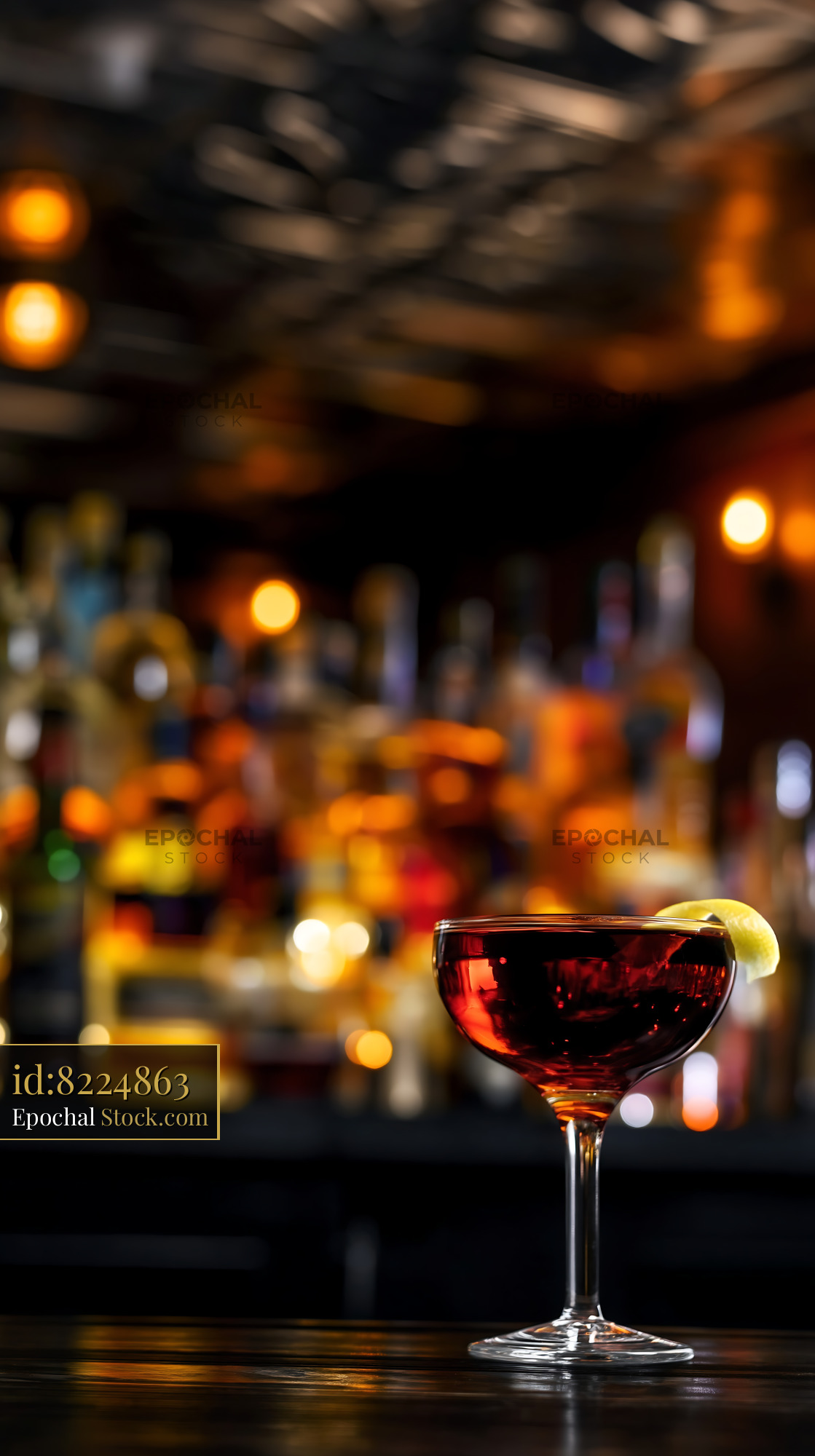 Luminous Red Cocktail with Lemon Garnish at Dark Bar - stock photo