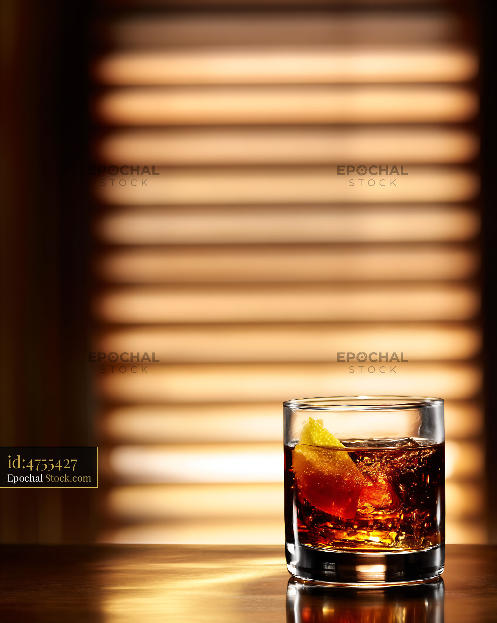 Iced Cocktail with Lemon Wedge in Warm Light - stock photo