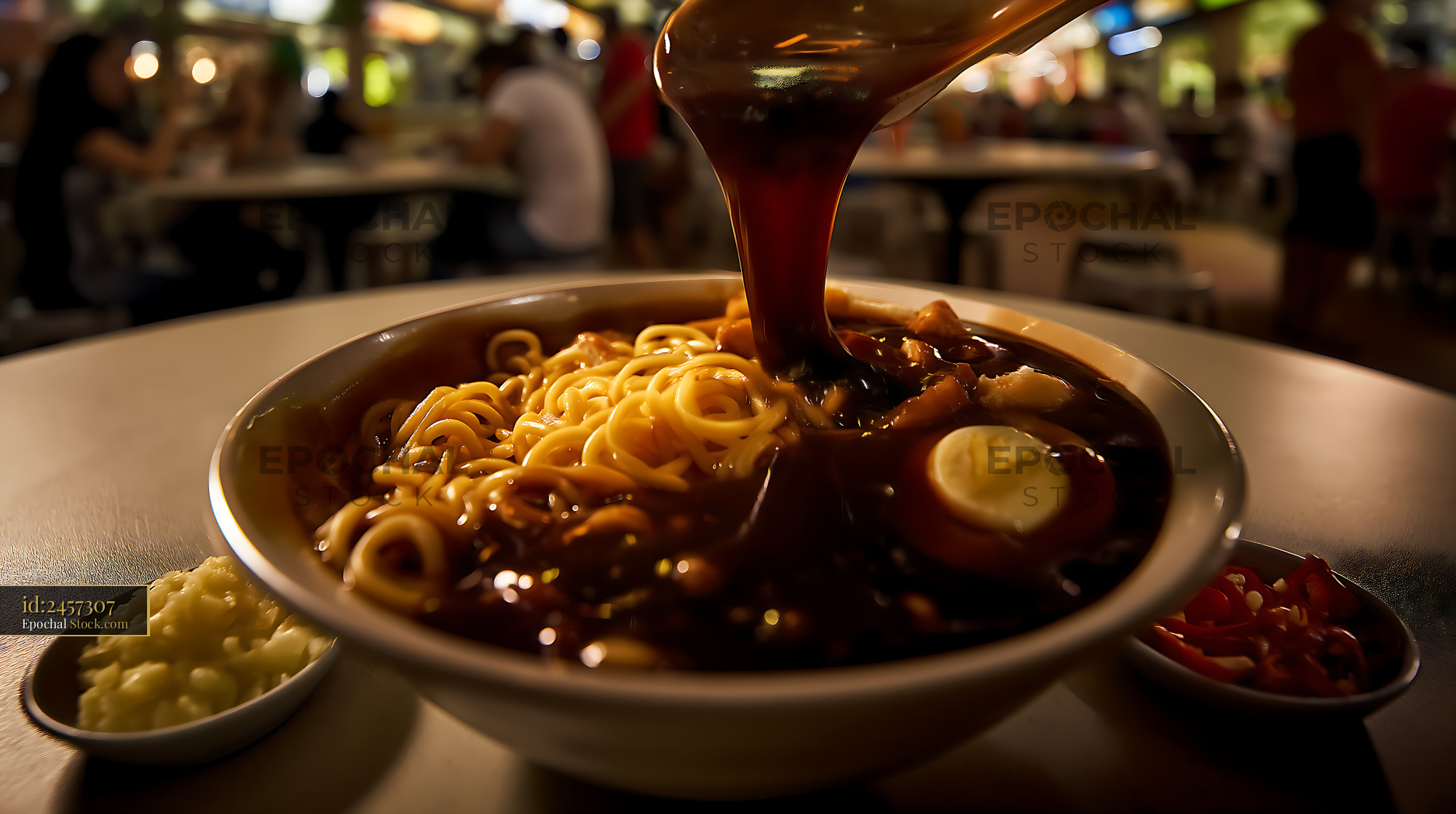 Dark Sauce Pouring Over Noodles in Busy Restaurant - stock photo