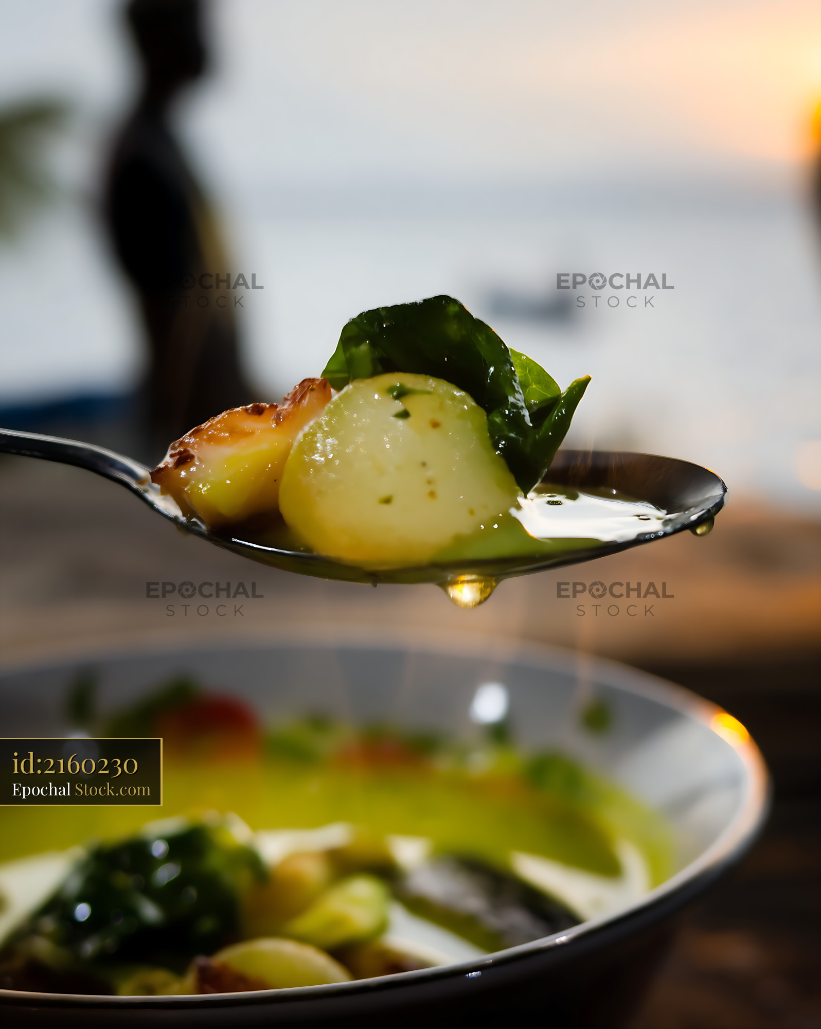 Spoonful of Kapurung Soup Dripping Outdoors at Sunset - stock photo