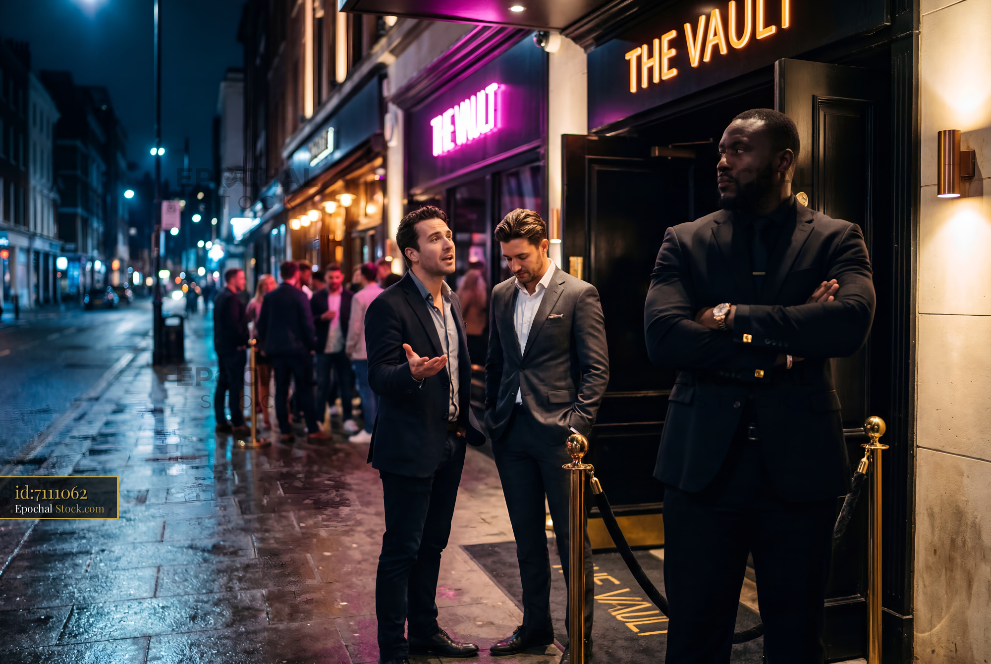Men wait outside a club on a rainy night in the city Premium Stock Image