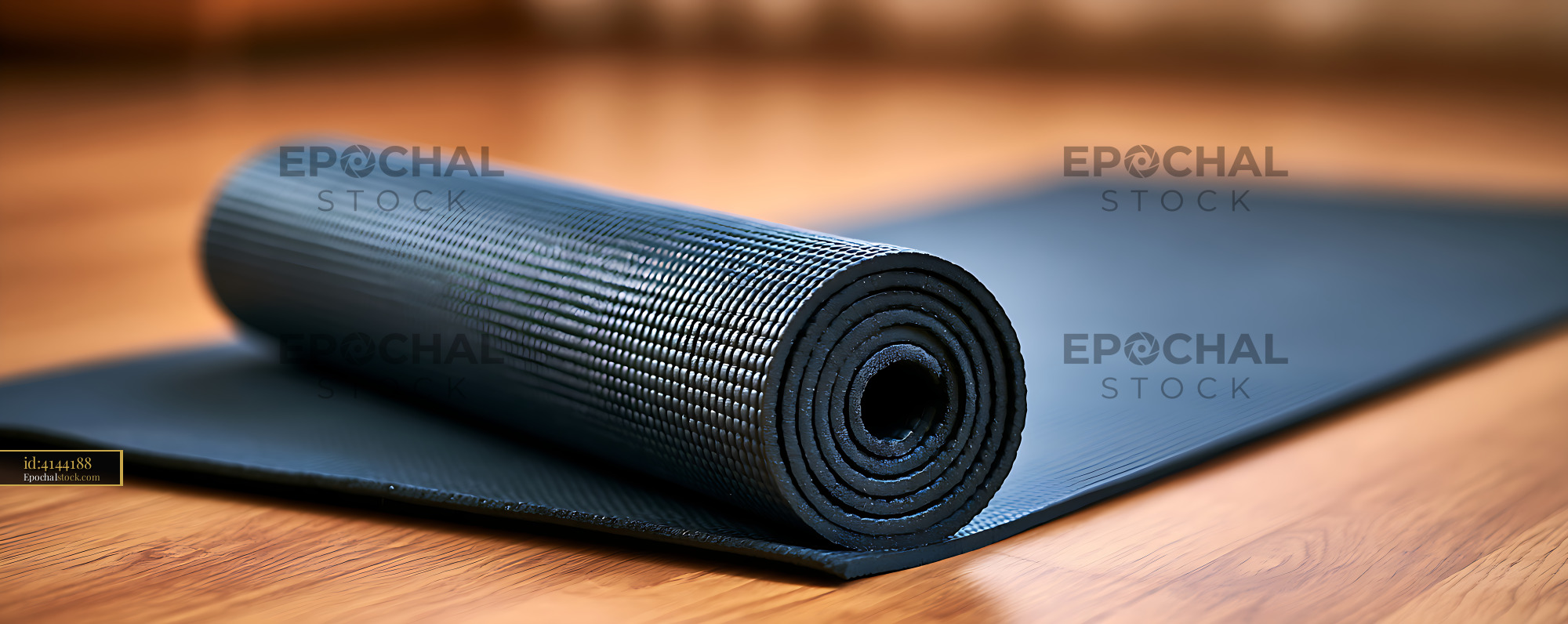 Watermarked full-resolution preview of Black rolled exercise mat on wooden flooring