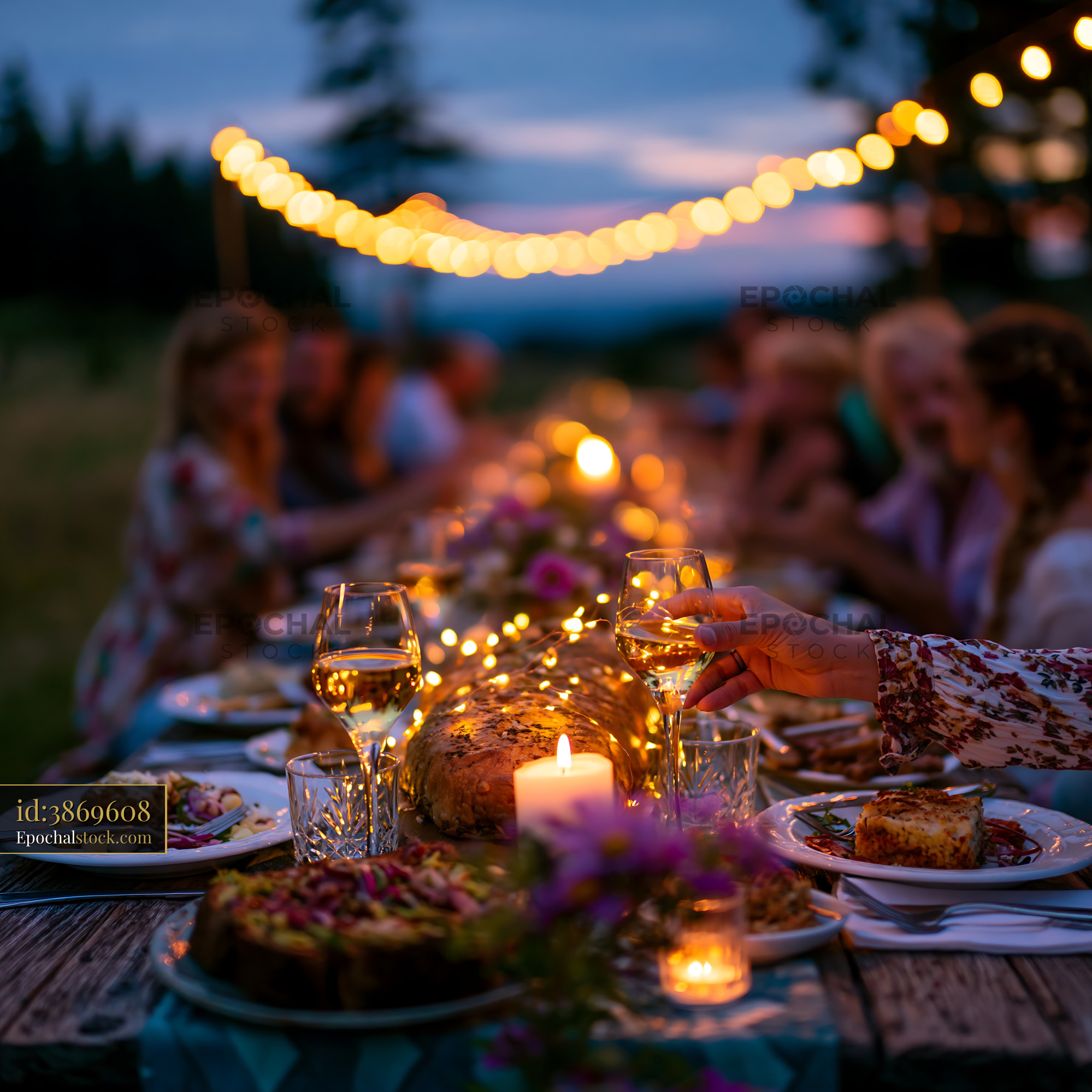 Watermarked full-resolution preview of Outdoor dining event with people enjoying food at sunset