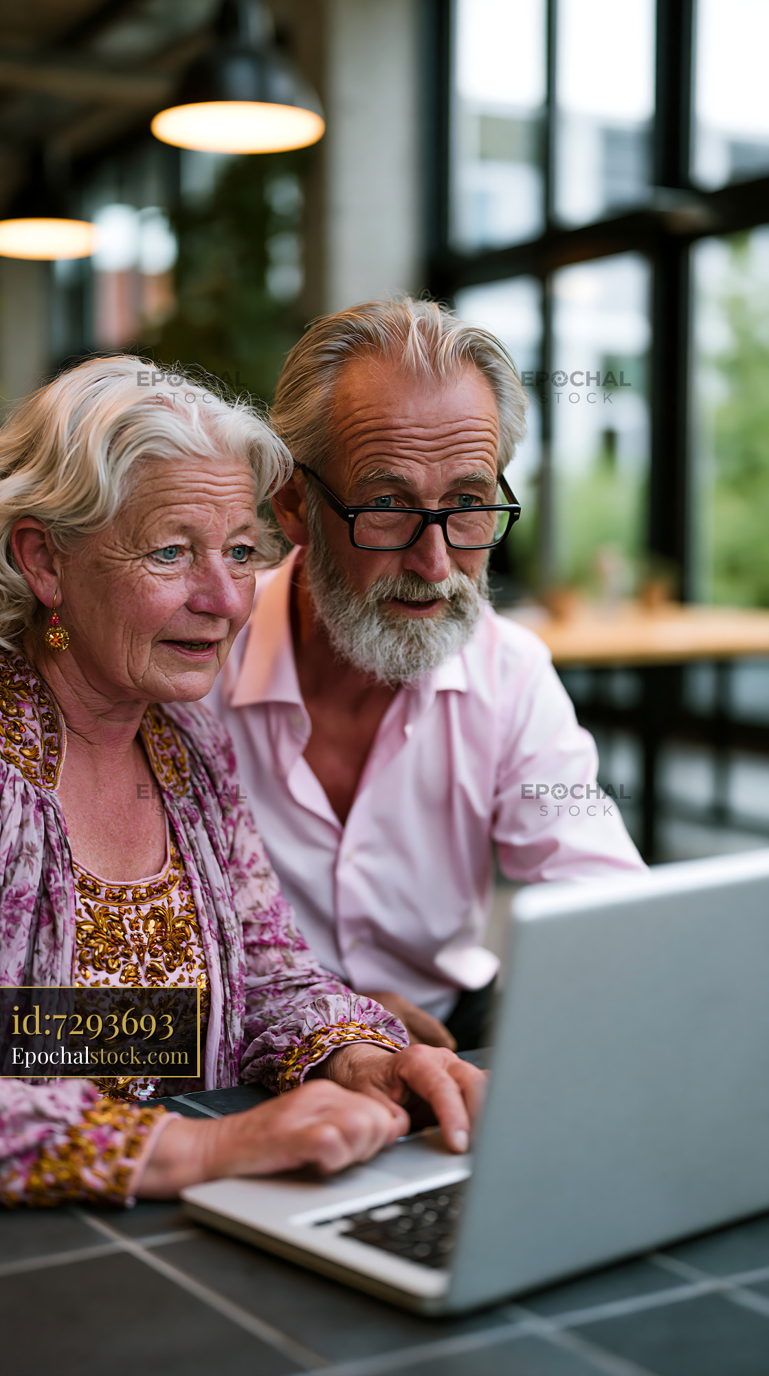 Watermarked full-resolution preview of Seniors enjoying technology together in a modern workspace