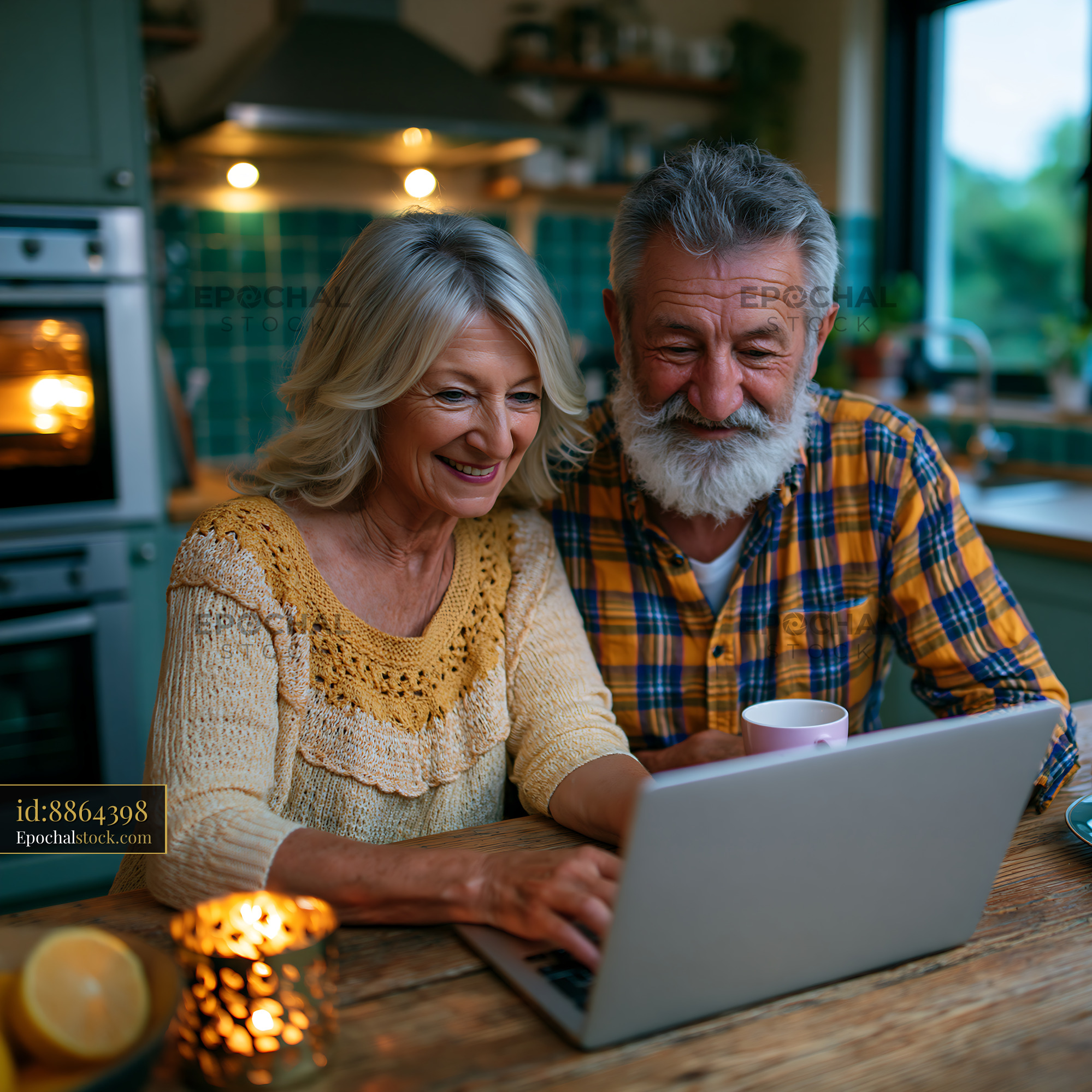 Watermarked full-resolution preview of Senior couple using laptop in cozy kitchen