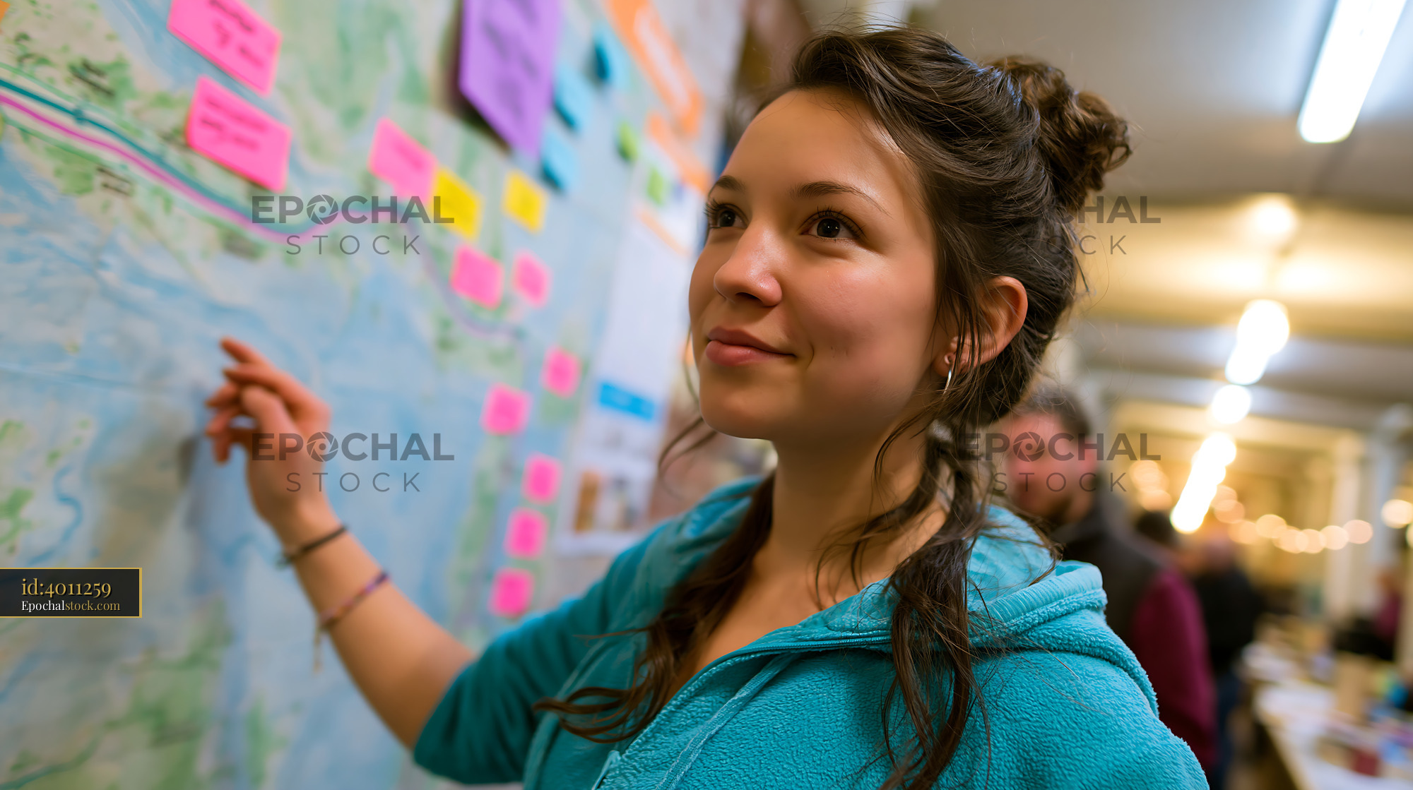 Watermarked full-resolution preview of Young woman engages with a map at a community event