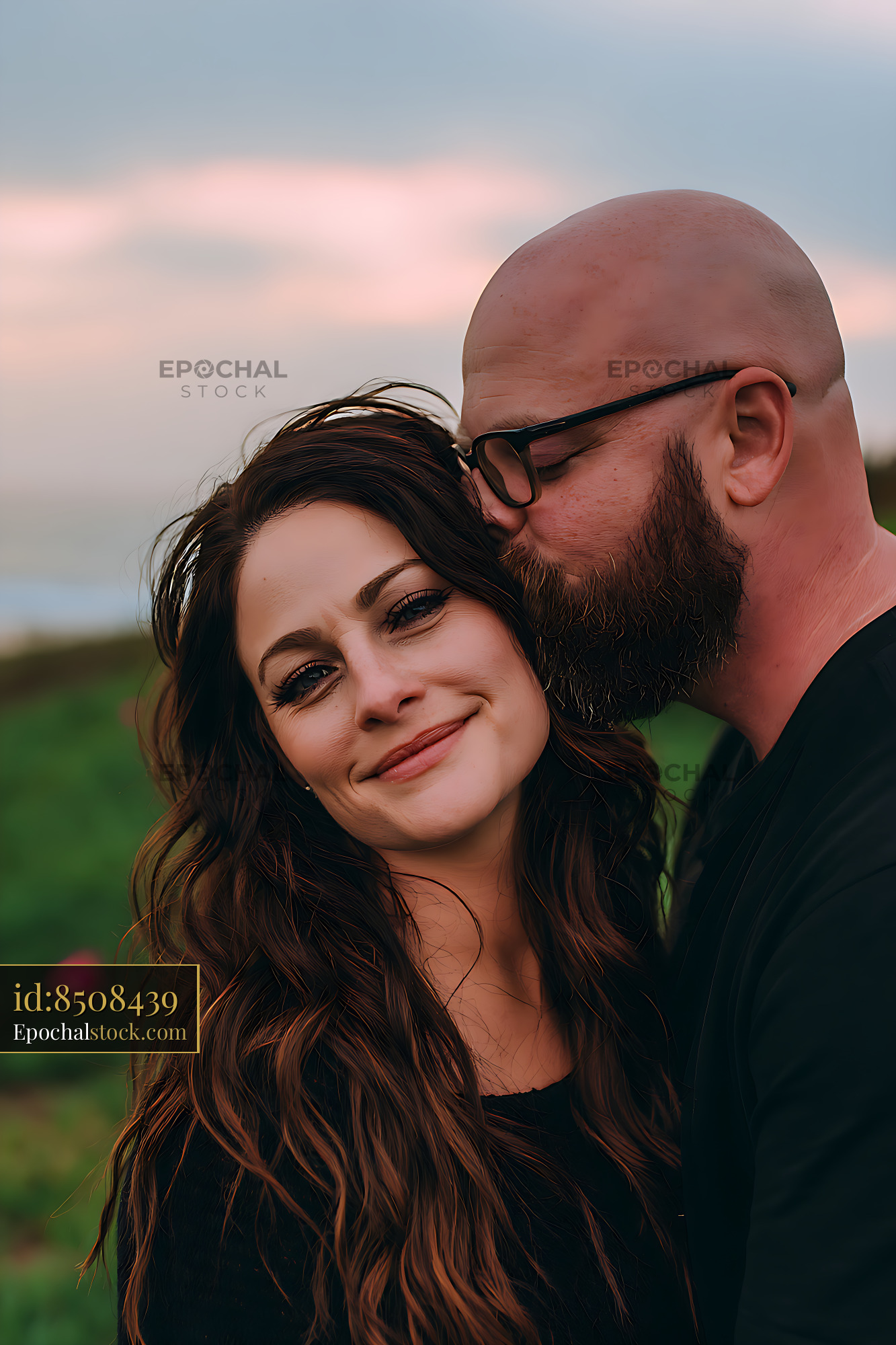 Watermarked full-resolution preview of Smiling couple sharing an affectionate outdoor embrace
