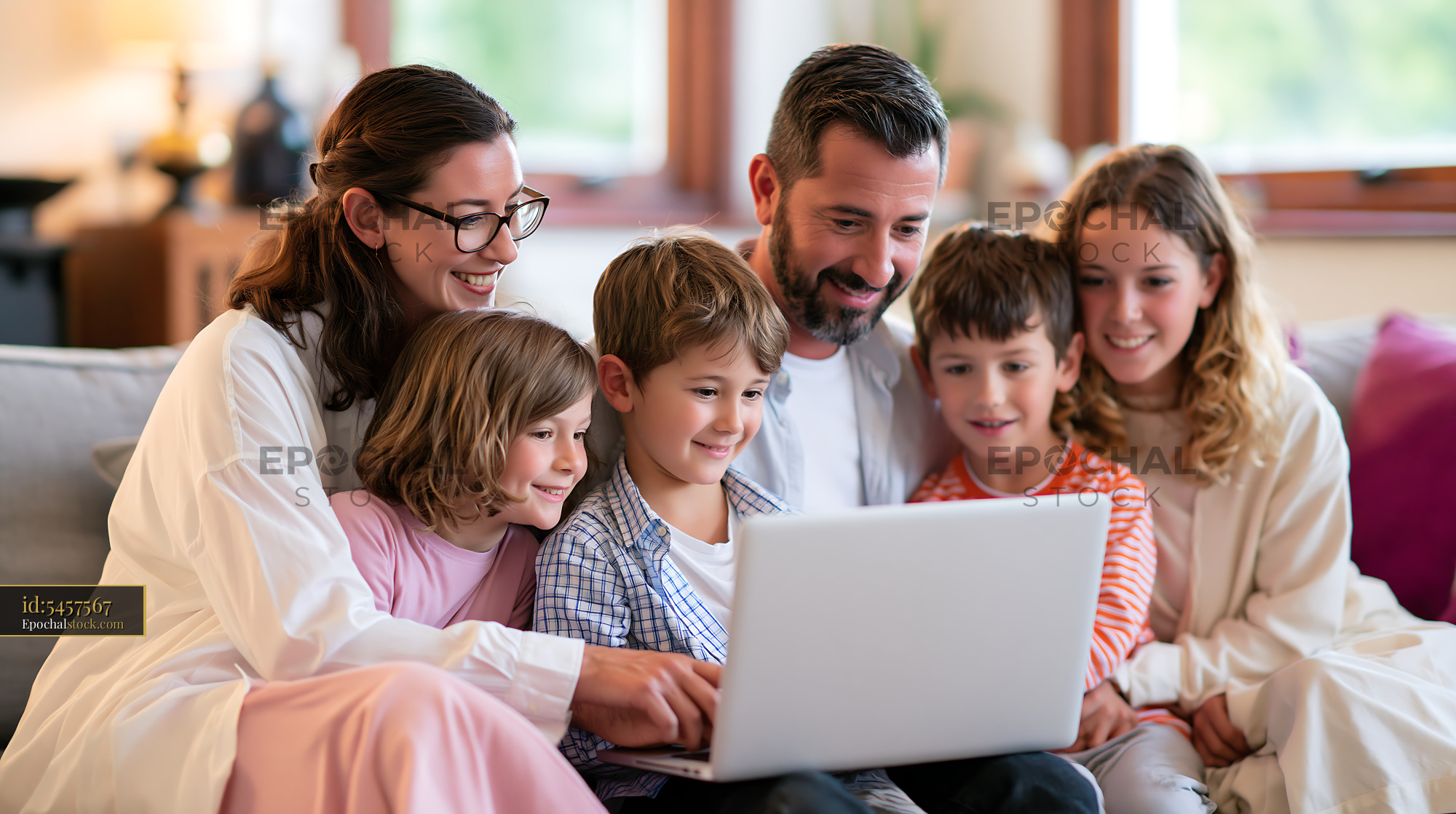 Watermarked full-resolution preview of Family enjoying time together with a laptop at home
