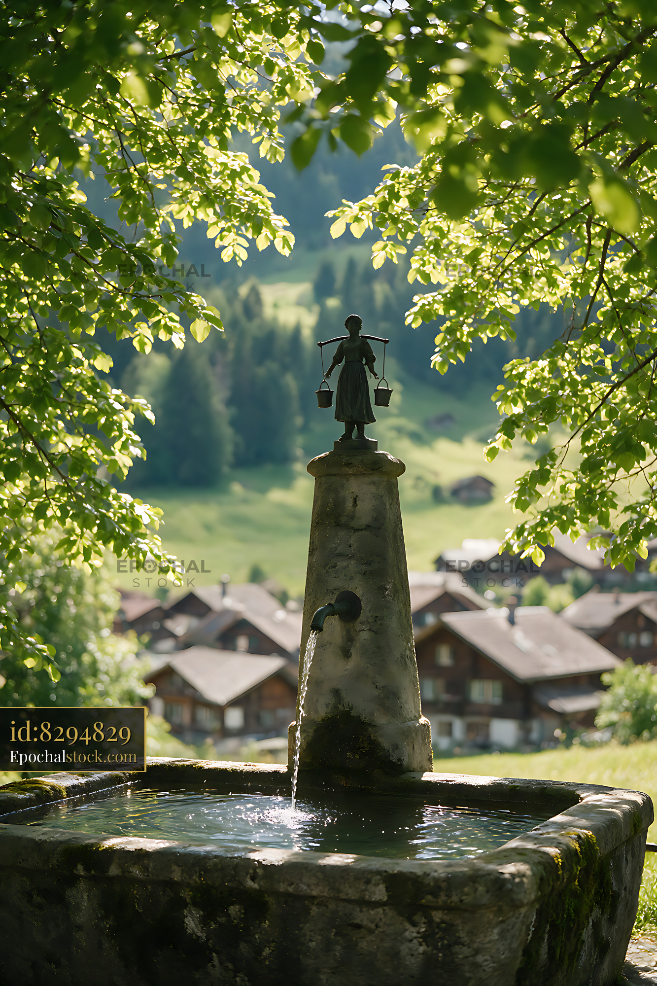 Watermarked full-resolution preview of Historic Swiss Village Fountain Beneath Leafy Trees