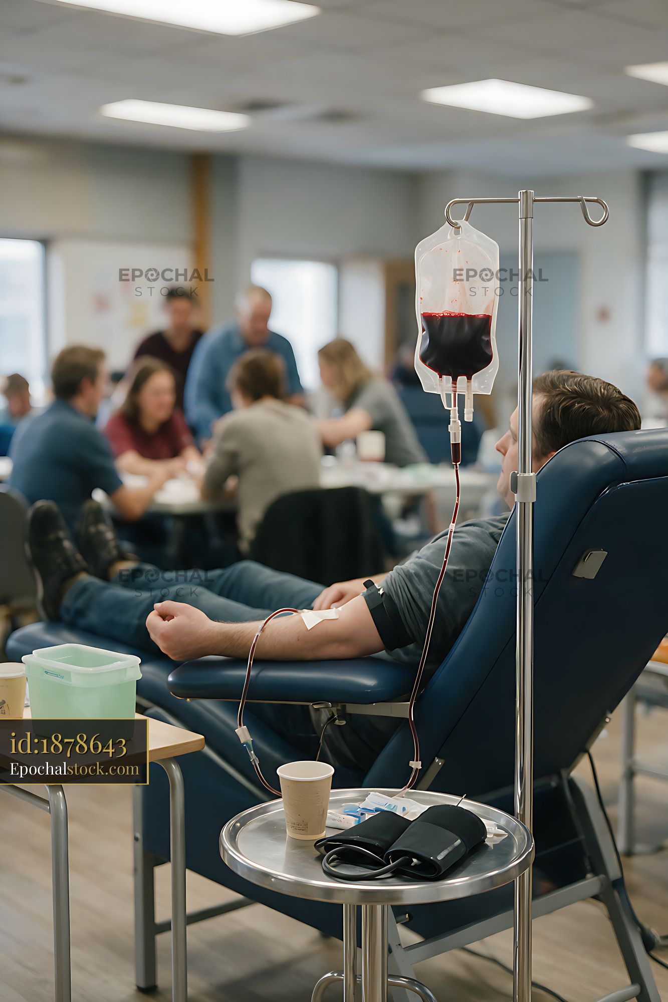 Watermarked full-resolution preview of Blood donor reclining in chair at donation center