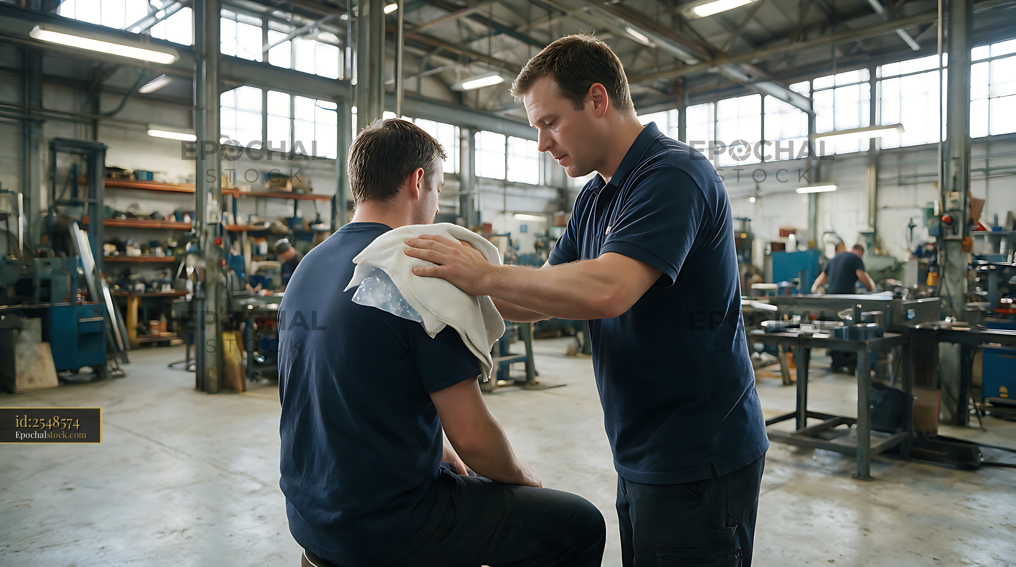Watermarked full-resolution preview of Coworker provides first aid to injured worker at work